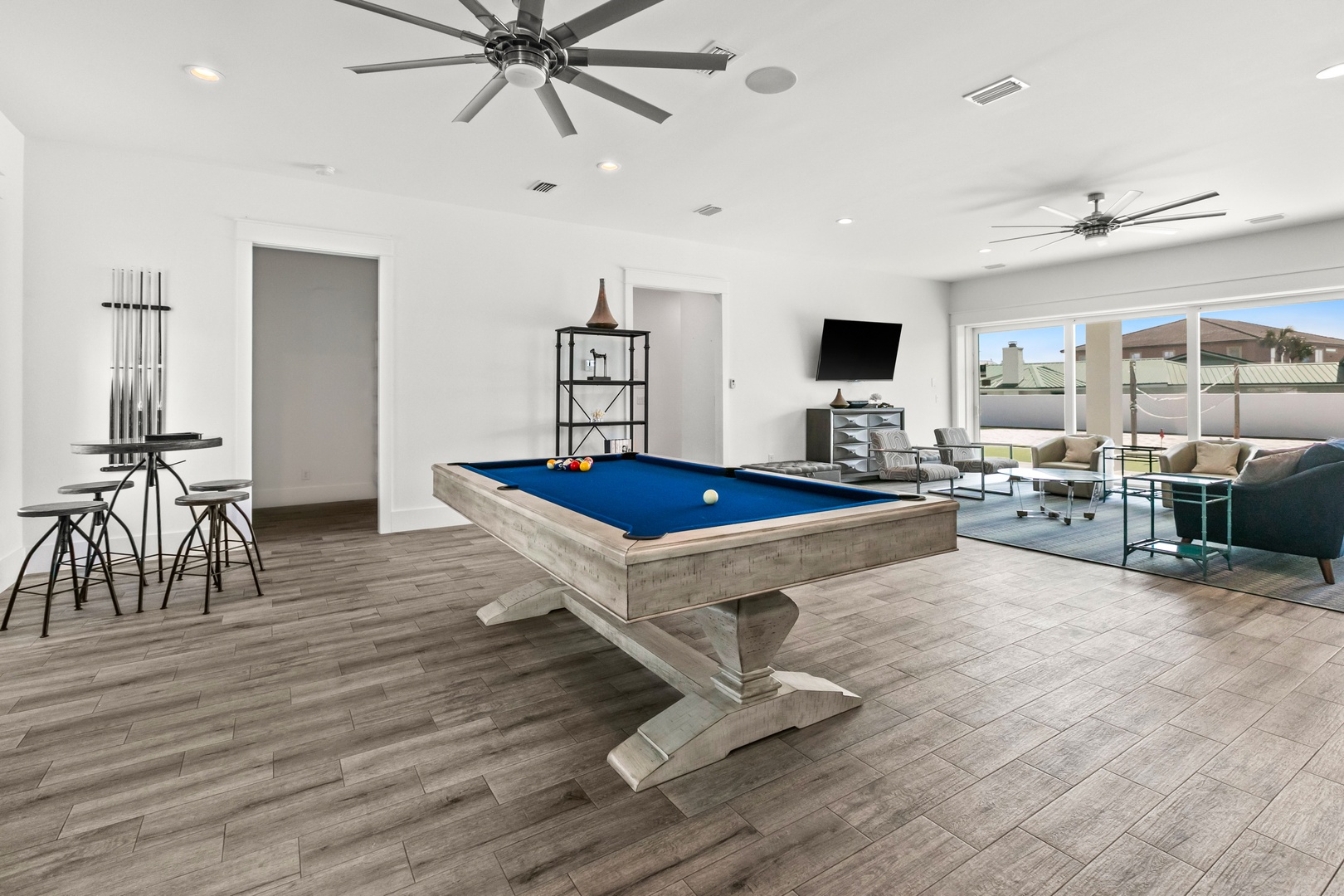 Challenge your friends to a friendly game of pool in this bright, modern game room. Floor-to-ceiling windows flood the space with natural light while you relax on comfortable seating between rounds.