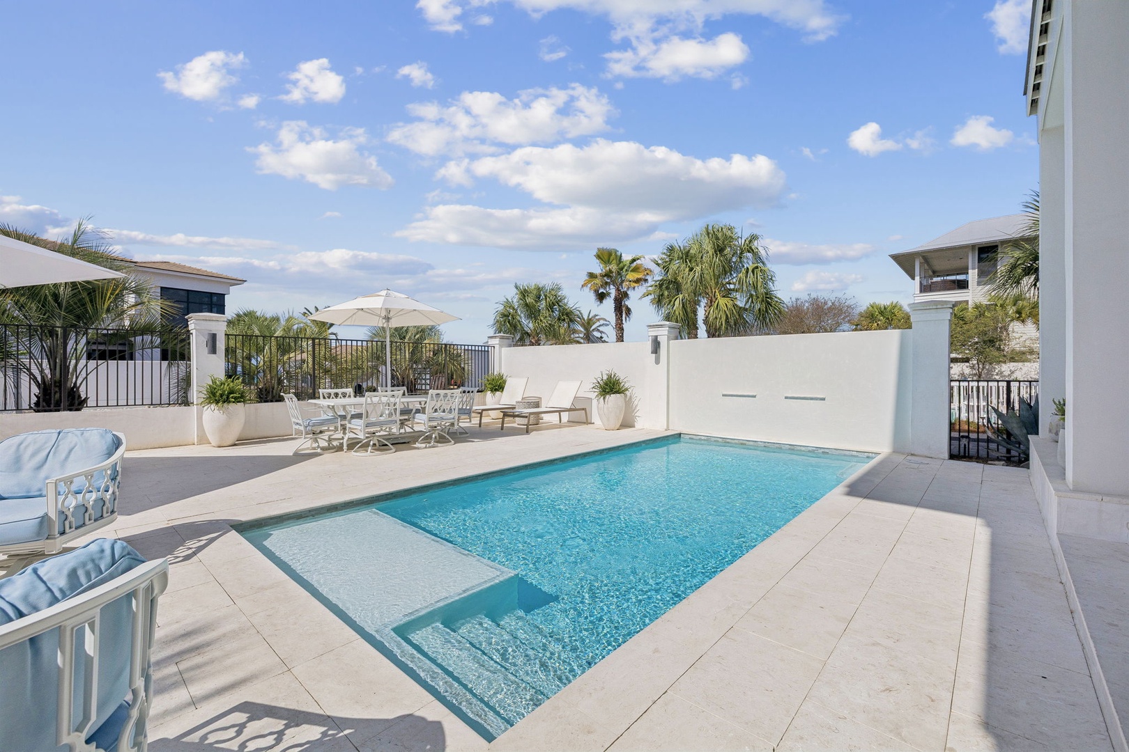 Dive into your private oasis with crystal-clear waters surrounded by tropical palms and elegant poolside loungers.