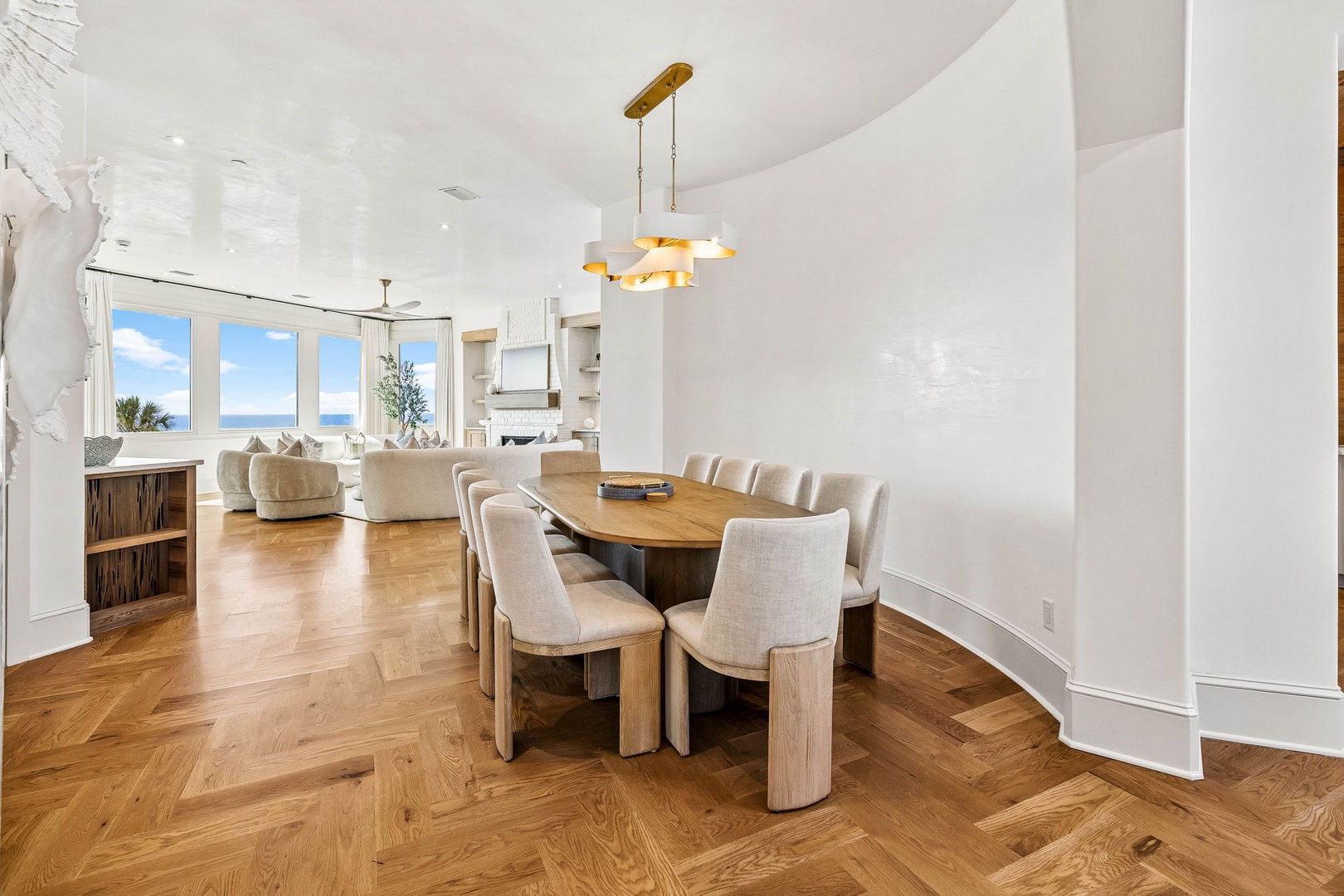 Gather around this elegant dining table with ocean views framing every meal, where coastal breezes and natural light create your perfect setting for memorable moments.