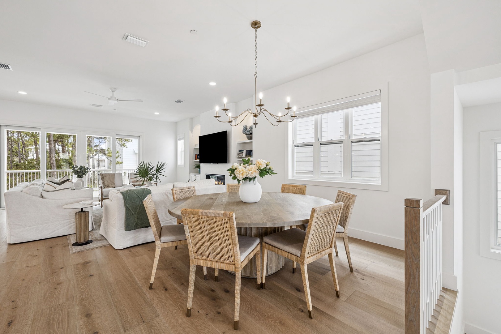 Gather around your elegant dining table in this bright, open-concept space where coastal charm meets modern comfort perfectly.