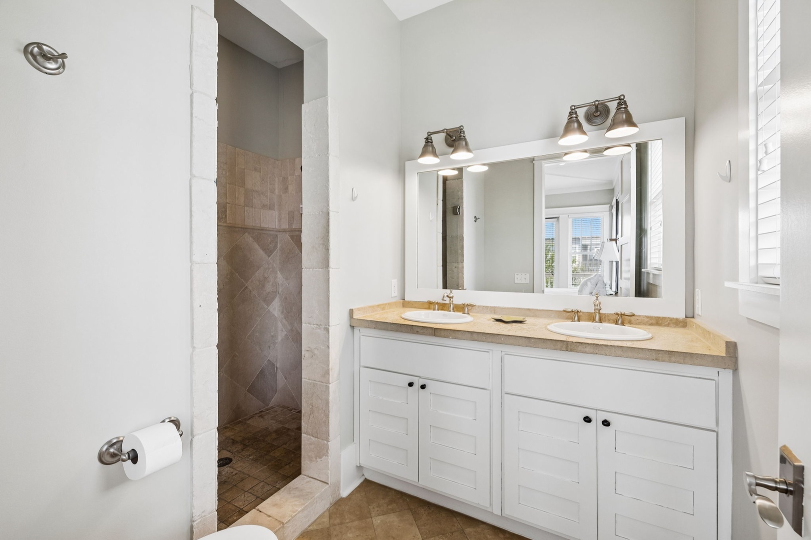 Bright and beautifully appointed, your ensuite bathroom offers dual vanities, elegant lighting, and a spacious walk-in shower—perfect for unwinding after a day of adventures.