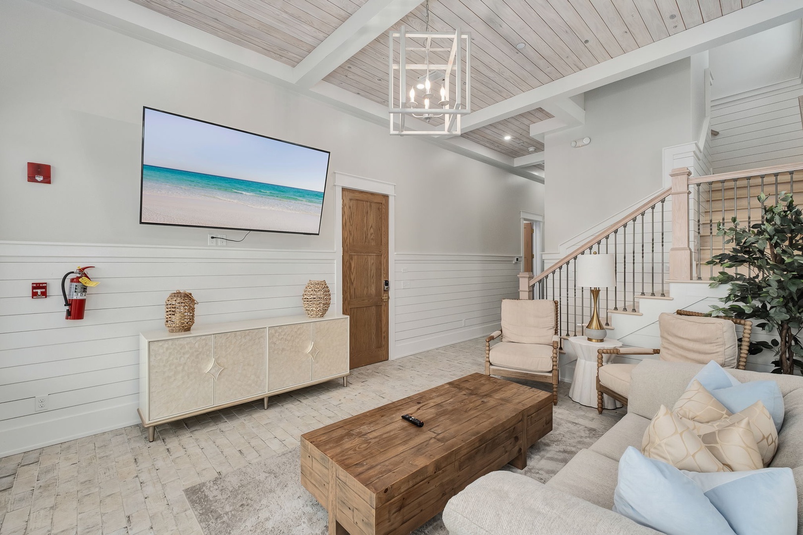 Unwind in your elegant living room featuring soaring ceilings, coastal artwork, and plush seating perfect for relaxing evenings.