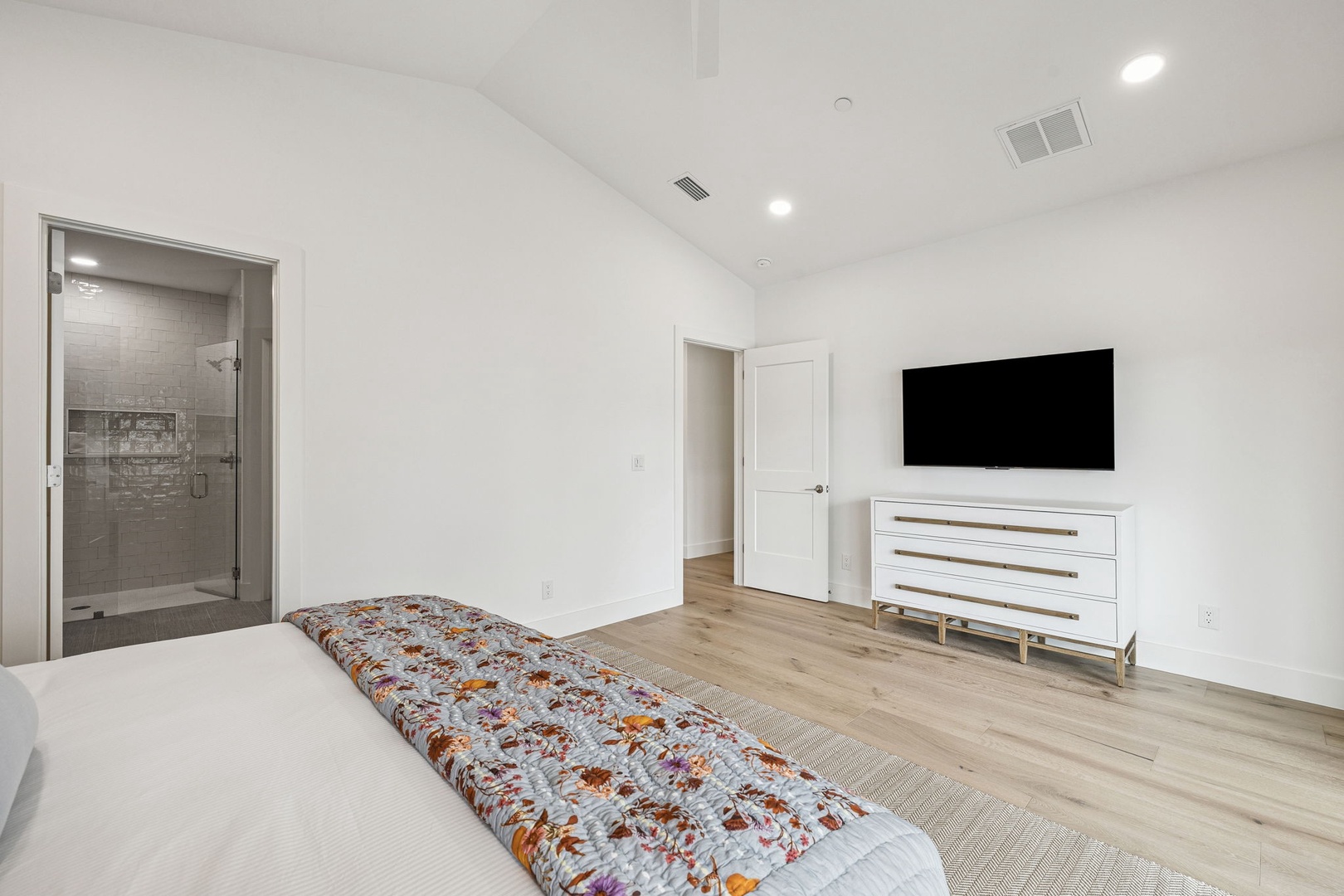 Your spacious master suite features a luxurious ensuite with elegant glass shower and modern TV entertainment setup.