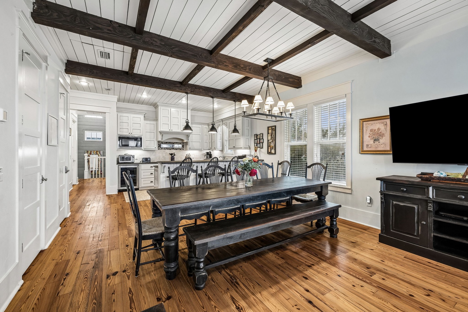 Gather around this inviting farmhouse dining table where rustic exposed beams overhead and warm hardwood floors create the perfect atmosphere for your family meals and vacation memories.