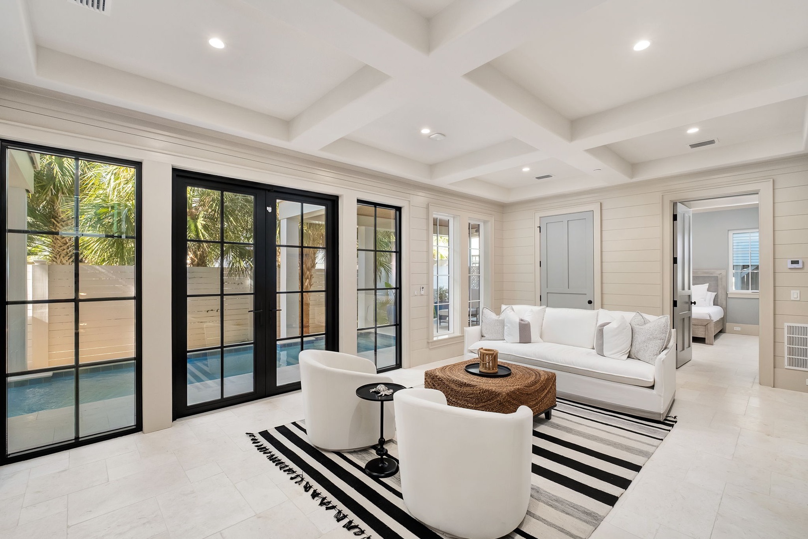 Unwind in this stunning living room where plush white sofas and elegant coffered ceilings create your perfect relaxation sanctuary.