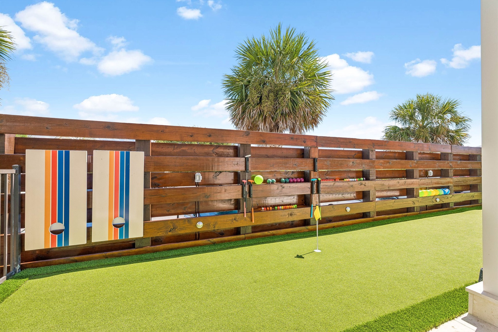 A private putting green beckons you to practice your short game under sunny skies, surrounded by tropical palms and playful outdoor games for all ages.