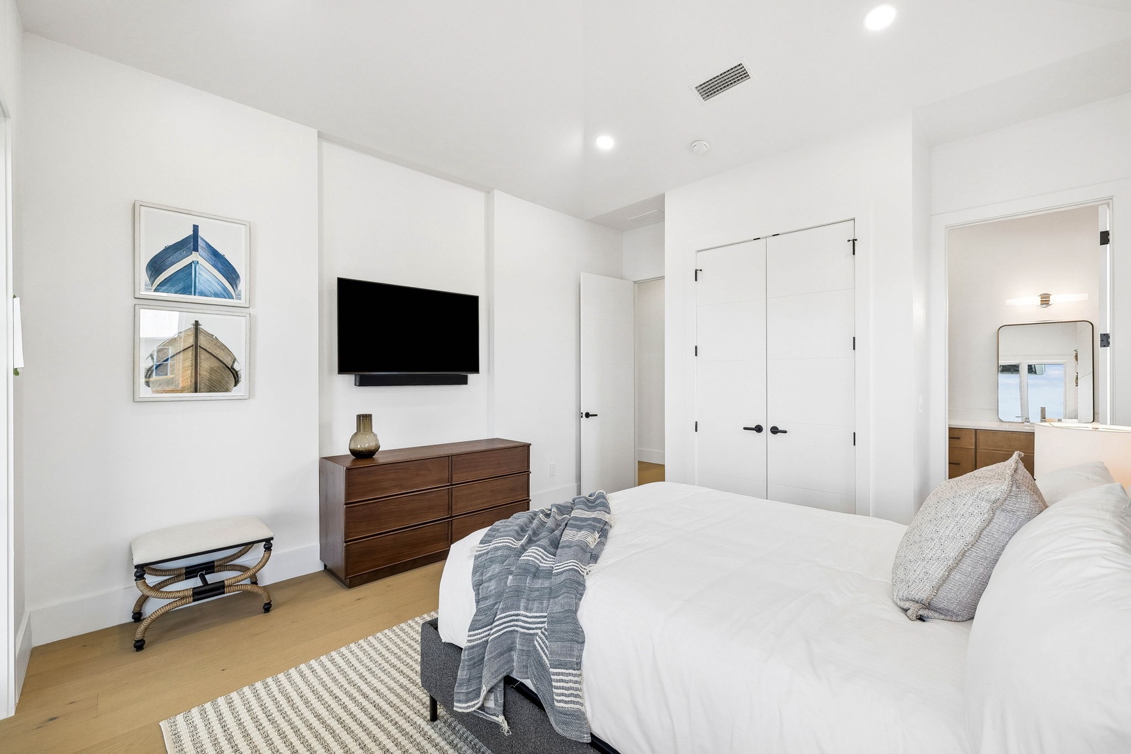 Slip into crisp white linens and unwind in your serene bedroom, complete with a flat-screen TV and cozy nautical touches. The en-suite bath awaits just steps away for ultimate convenience.