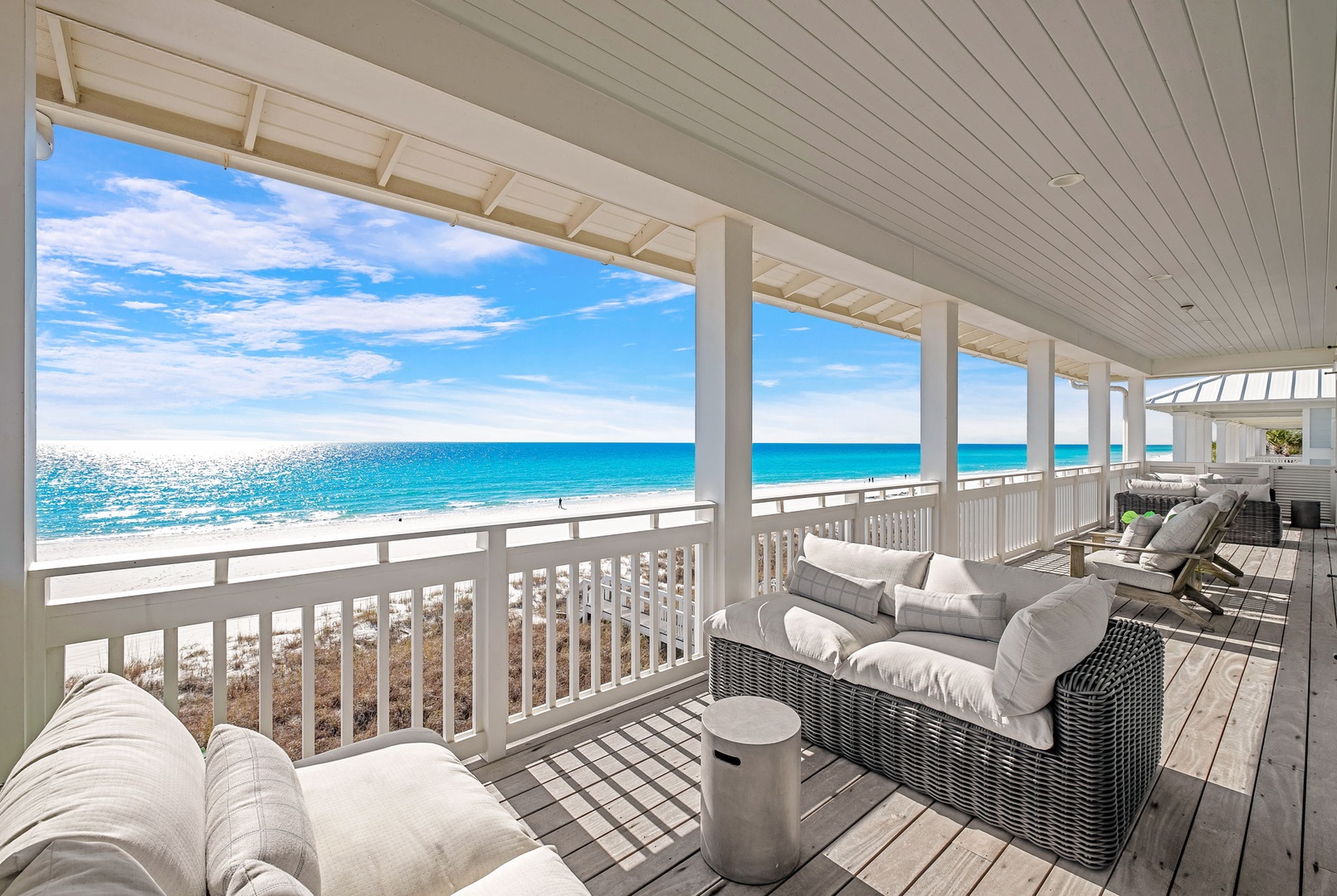 Relax on your private beachfront balcony with plush seating, where turquoise waves and endless ocean views frame your perfect escape.