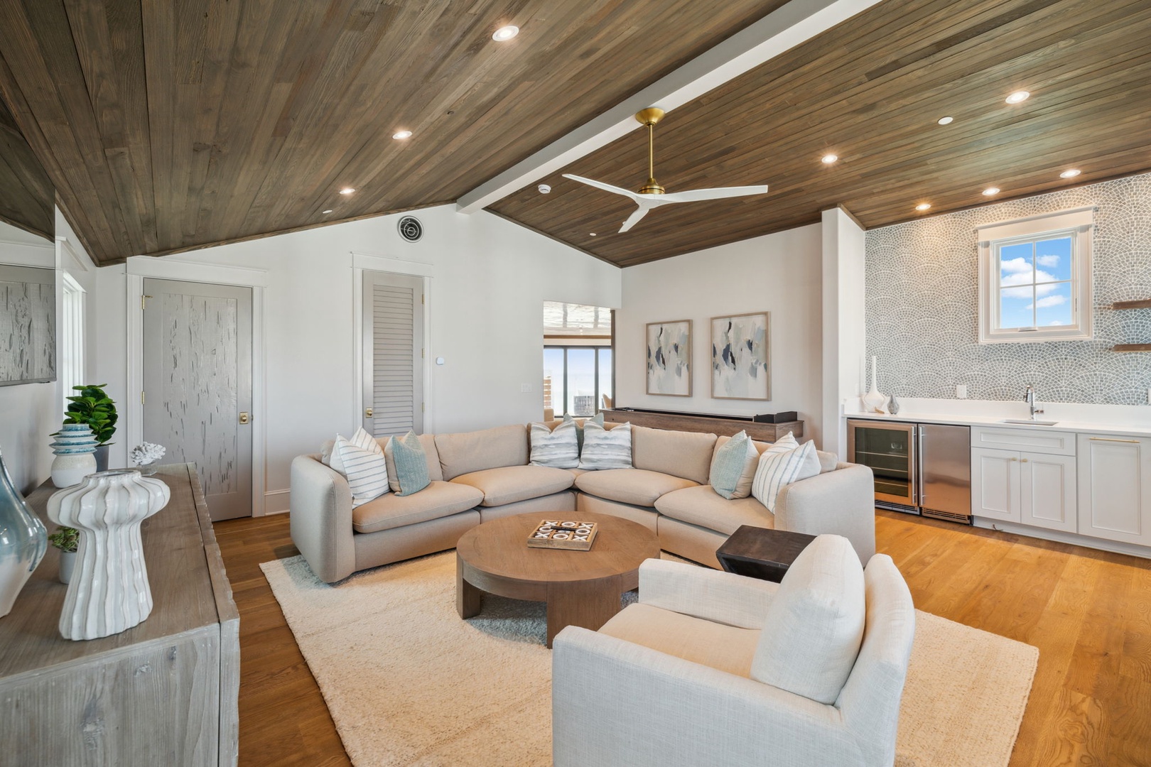 Picture yourself unwinding in this airy coastal retreat, where soft seating and a stunning wood-planked ceiling create warmth and relaxation for your stay.