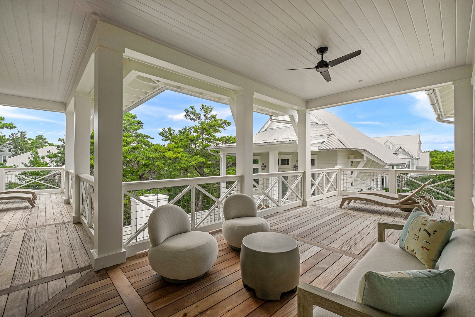 Unwind in your private covered deck, where comfortable seating invites you to relax beneath the ceiling fan as lush treetops frame peaceful views of the surrounding neighborhood.