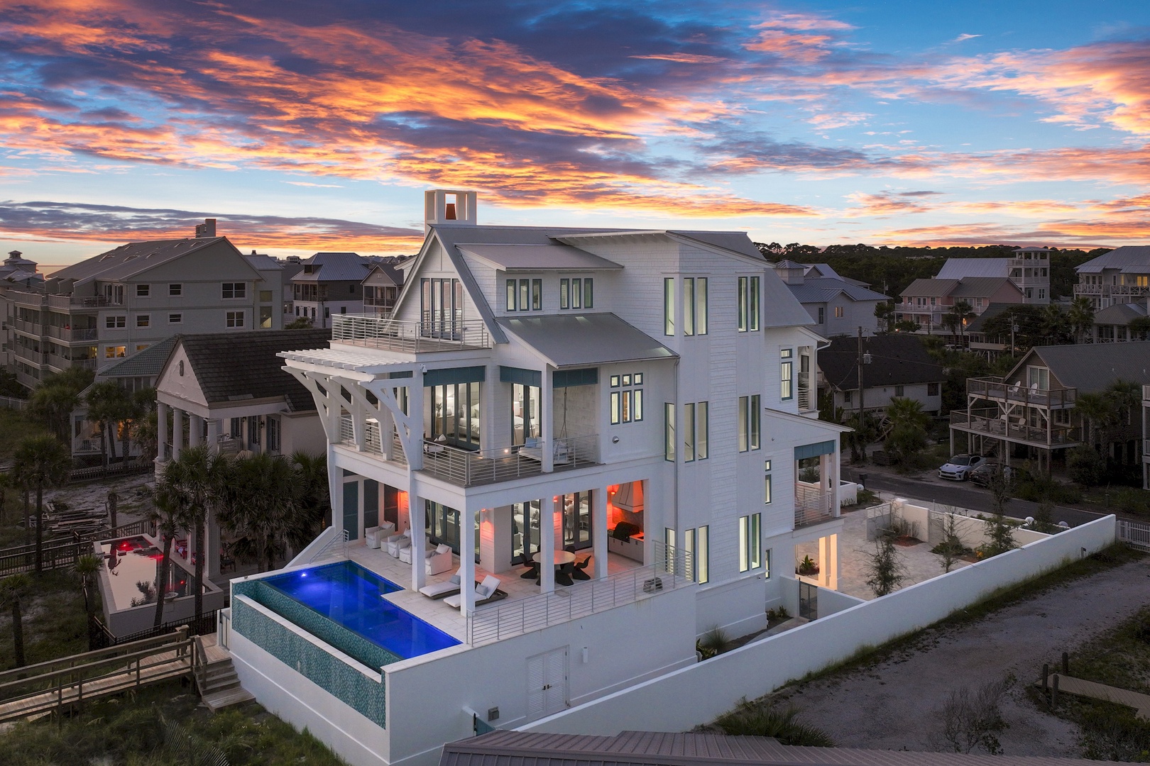 A stunning modern coastal retreat showcasing contemporary architecture and a sleek infinity pool, set against a breathtaking sunset in a serene beachside neighborhood.