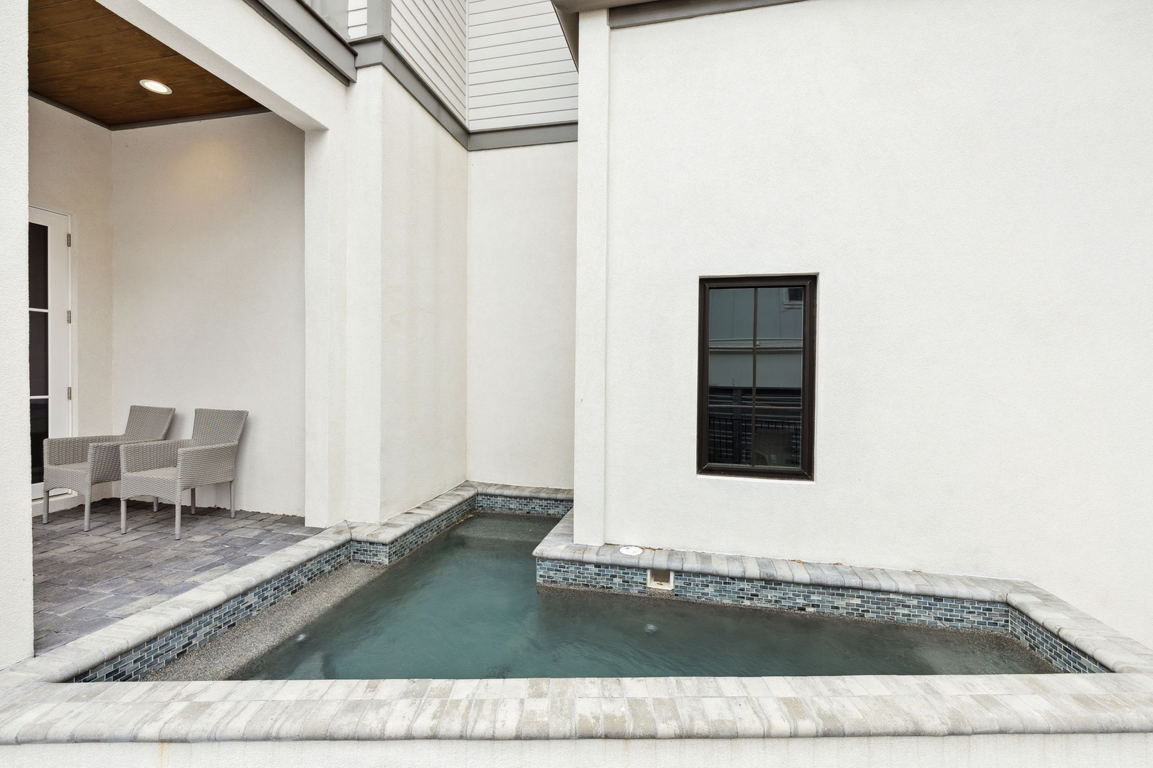 Your private spa awaits in this elegant courtyard with mosaic-tiled hot tub and comfortable seating for pure relaxation.