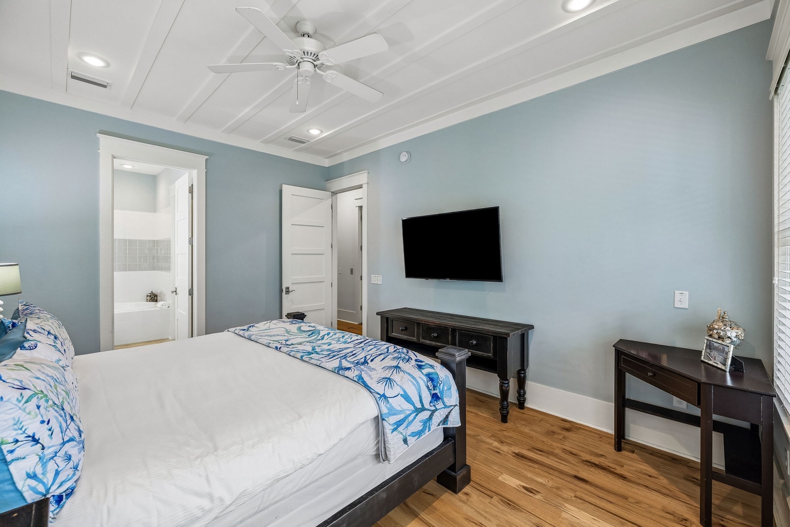 Unwind in your coastal-inspired bedroom with calming blue walls, gleaming hardwood floors, and a ceiling fan for perfect comfort. Your private en-suite awaits just steps away.
