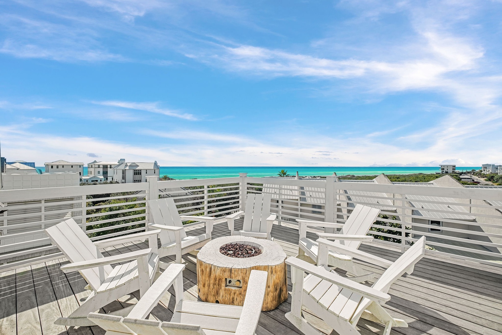 Your private rooftop deck with stunning ocean views features comfy Adirondack chairs around a cozy fire pit for unforgettable evenings.