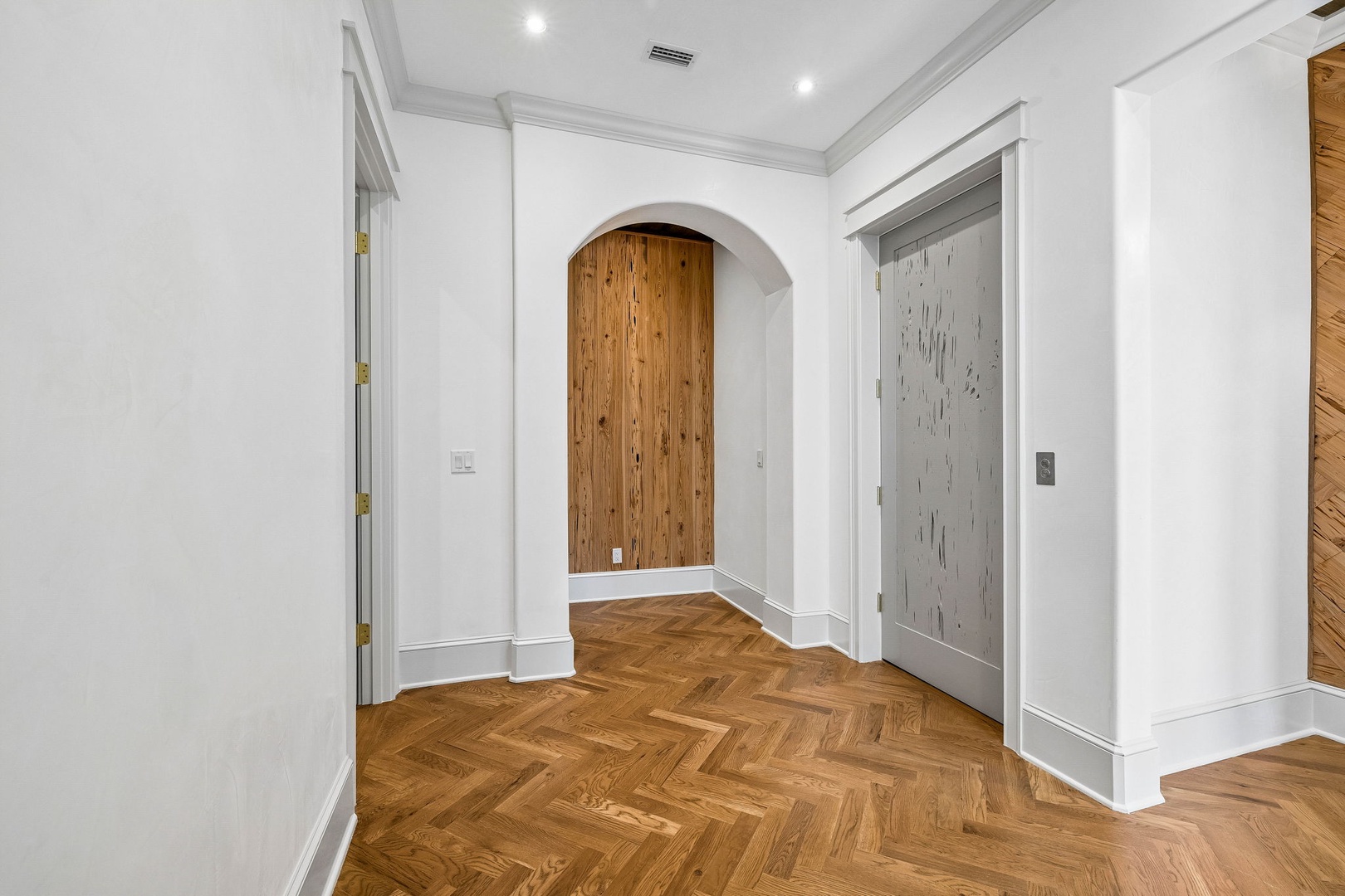 Step into your elegant entryway with stunning herringbone floors, crisp white walls, and tasteful wood accents that set a warm, sophisticated tone for your entire stay.
