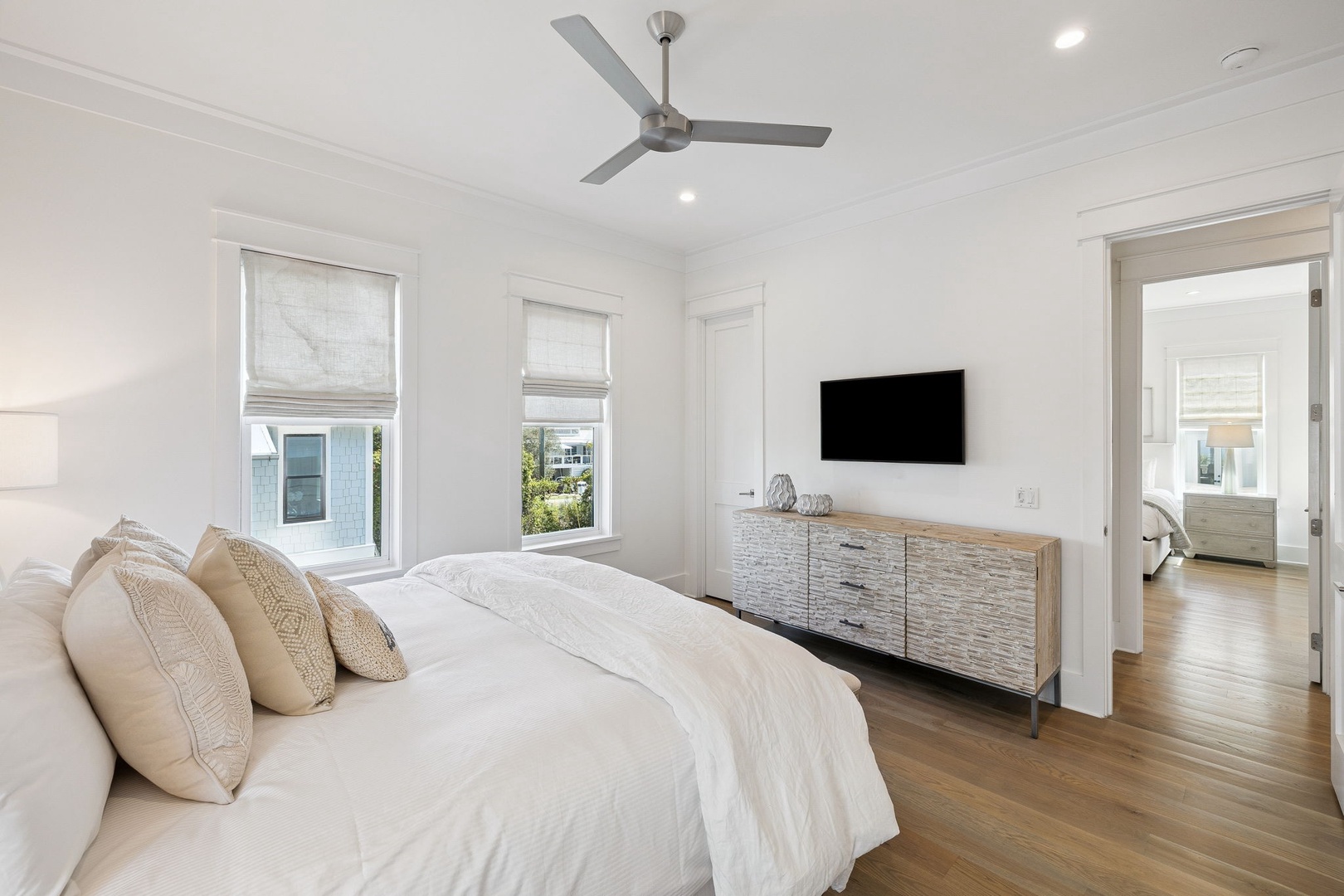 Unwind in your serene bedroom with crisp linens, modern furnishings, and peaceful natural light streaming through elegant windows.