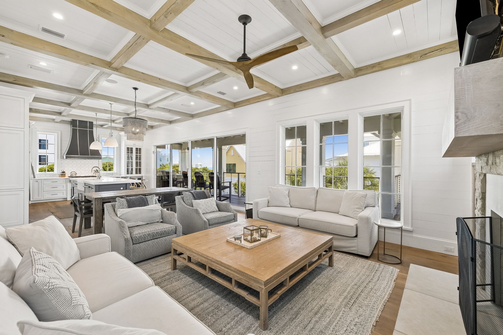 Unwind in your spacious living room where vaulted wood-beam ceilings meet soft coastal light. Sink into plush seating, savor the open-concept flow, and gaze through expansive windows at peaceful landscape views.