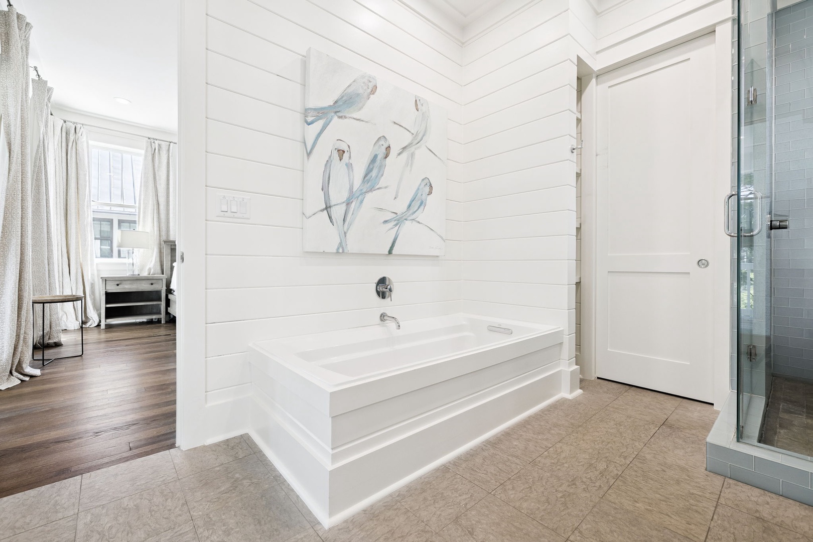 Unwind in your elegant soaking tub surrounded by coastal charm and shiplap walls that create the perfect retreat.
