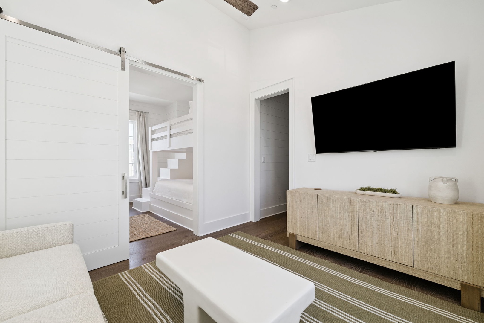 Relax in your stylish suite with modern furnishings, cozy seating, and a separate bedroom beyond the elegant sliding barn door.