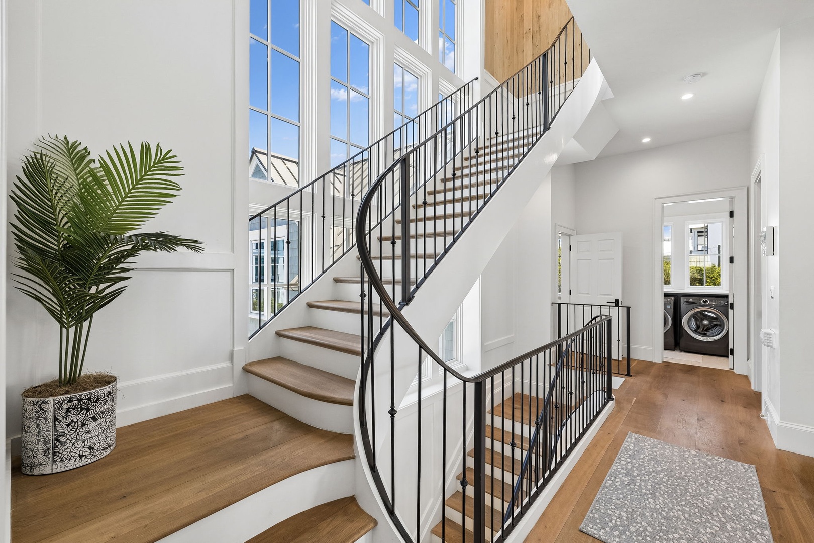 This bright, airy entryway welcomes you with soaring ceilings and natural light pouring through tall windows, setting a serene tone for your stay.