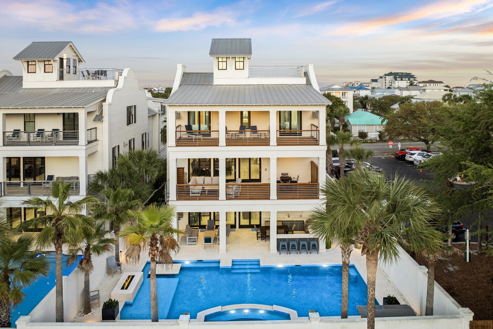 Modern coastal architecture features spacious balconies, a stunning pool, and palm-lined grounds in this upscale neighborhood setting.