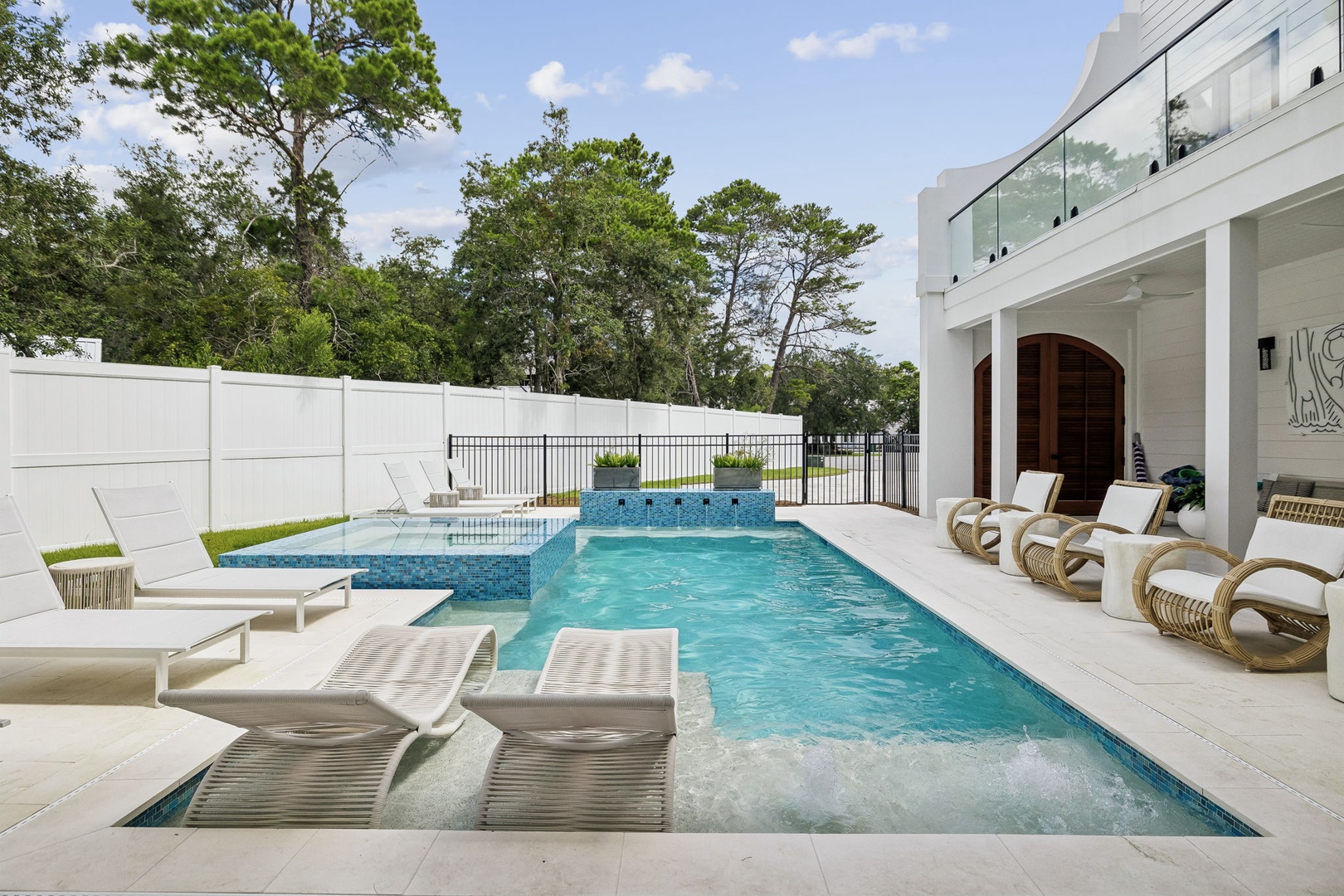 Step into your own private oasis—a sparkling pool with built-in loungers and a bubbling hot tub, all framed by lush greenery and shaded by towering pines. Perfect for unwinding under the sun or stars.