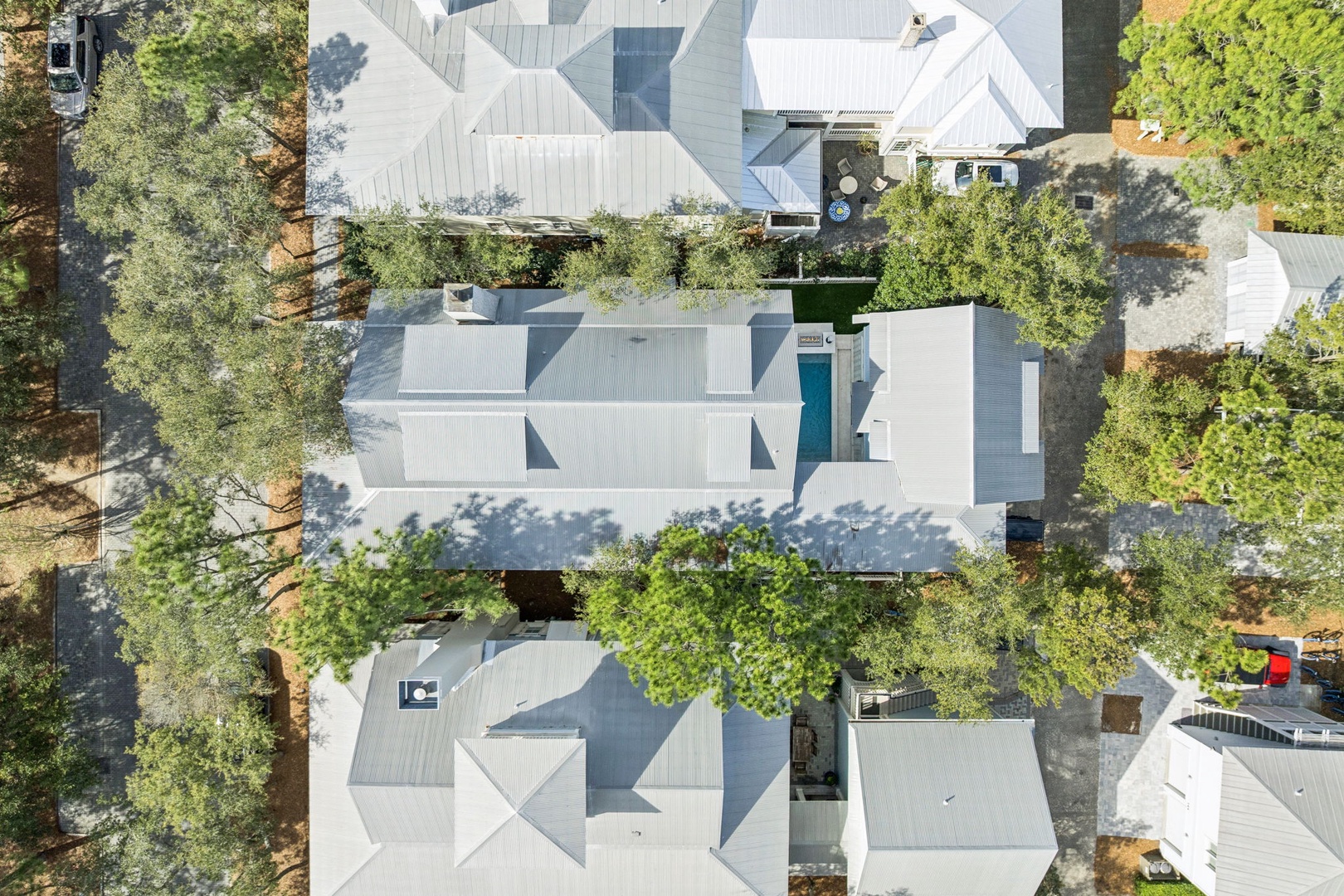 Aerial view showcasing the property nestled among lush trees in a peaceful residential neighborhood.