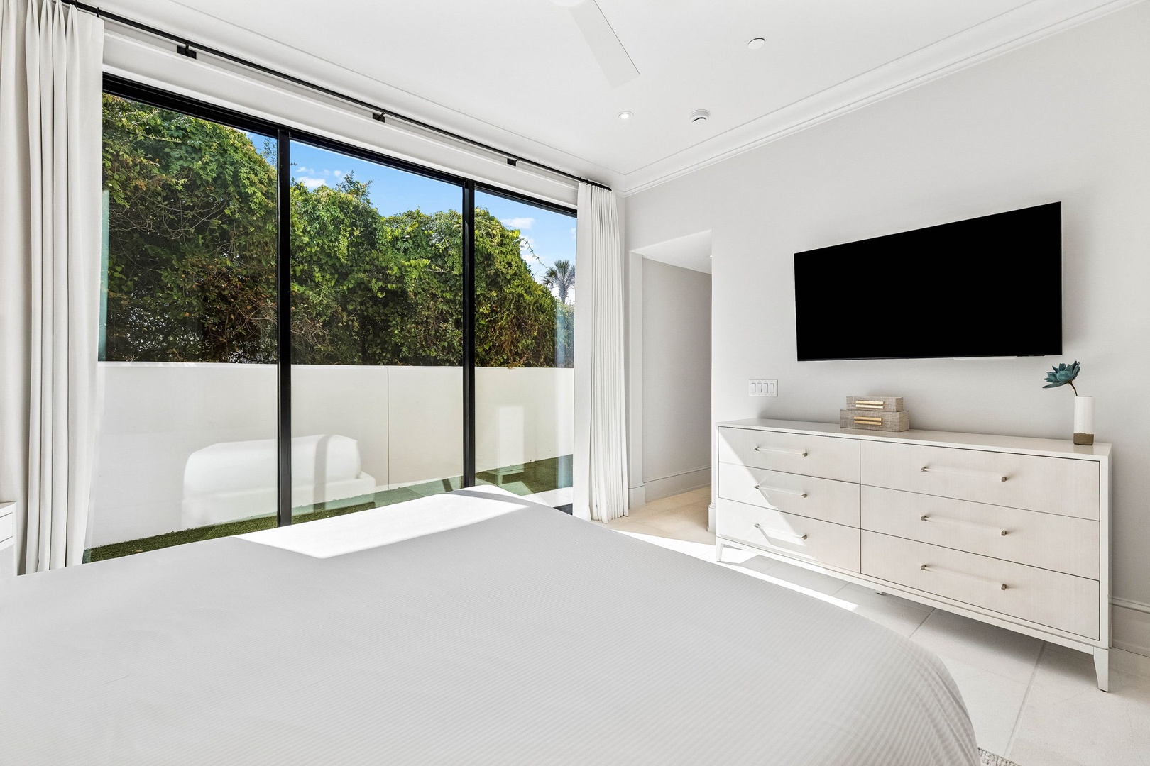 Wake up to natural light streaming through floor-to-ceiling windows framing your private garden view. A peaceful, modern retreat designed for ultimate relaxation.