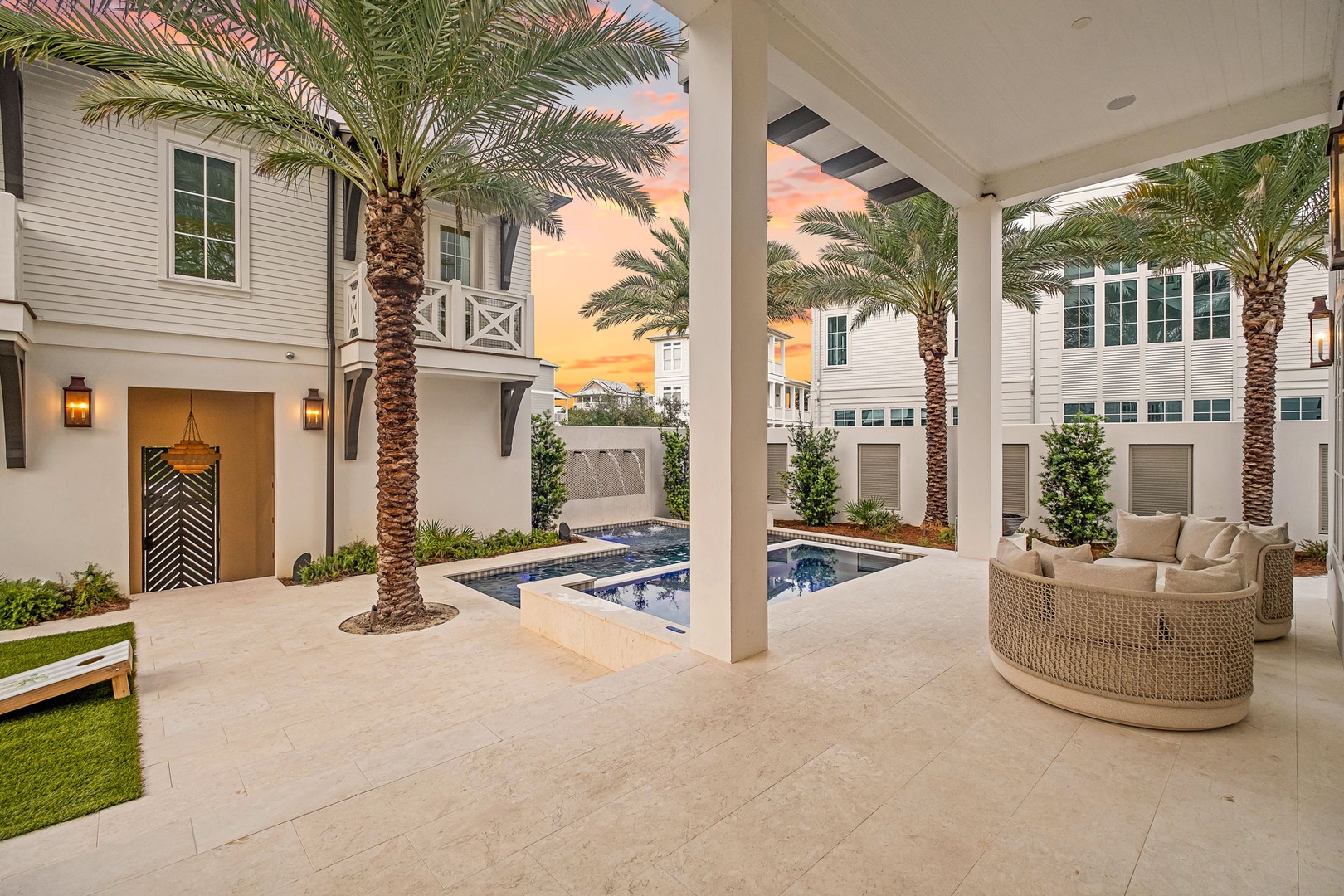 Private courtyard with sparkling pool and covered lounge area framed by swaying palms—your serene outdoor escape awaits.