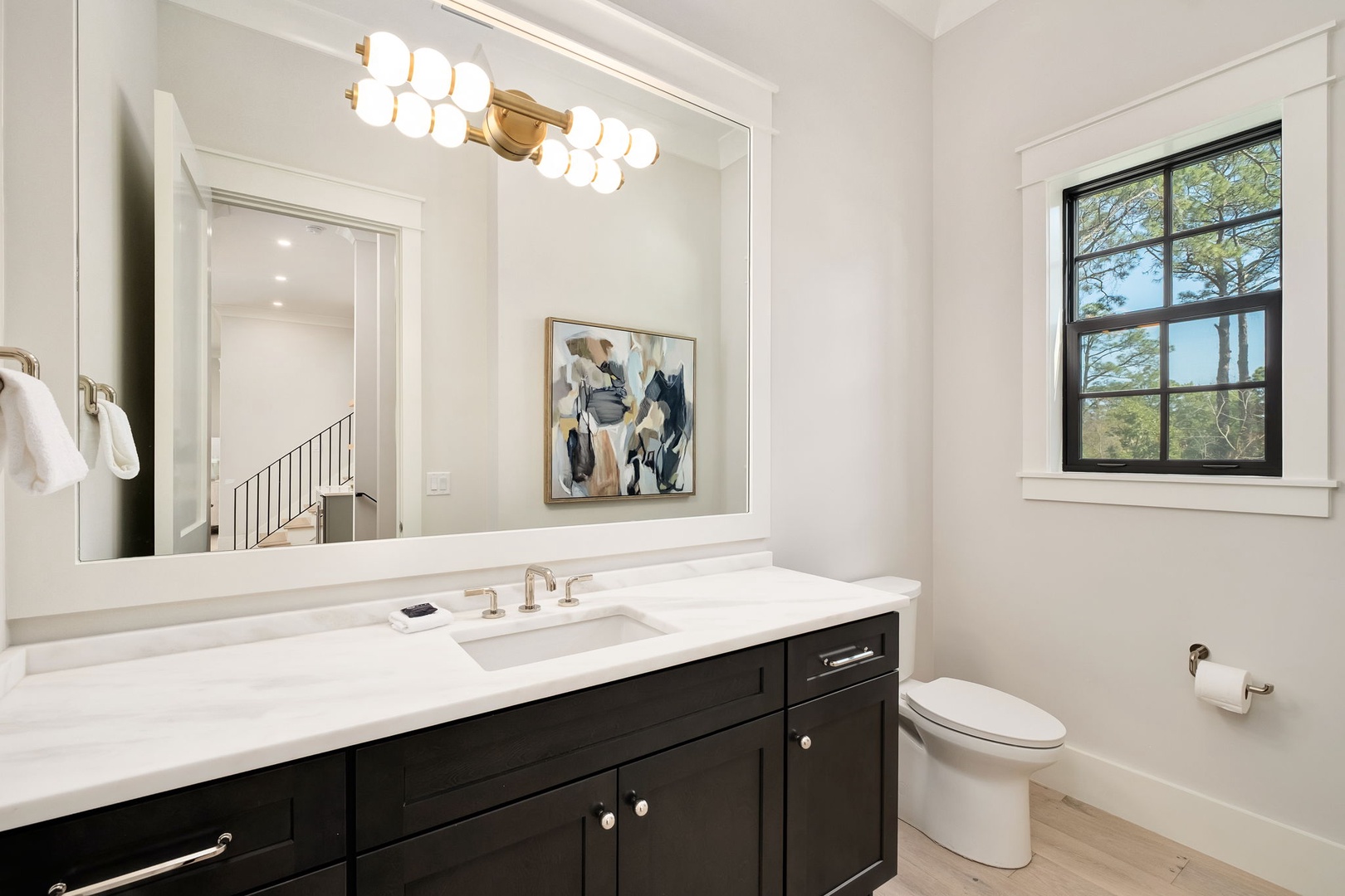 Freshen up in your elegant bathroom featuring a marble vanity, stylish lighting, and modern fixtures for your comfort.