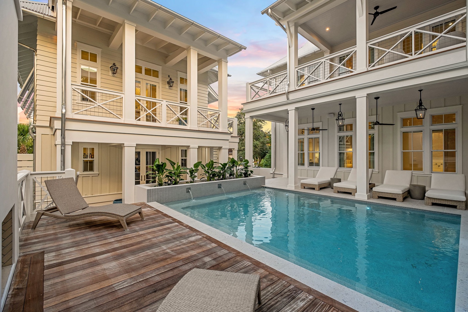 Your private courtyard paradise awaits, with a sparkling pool nestled between elegant balconies as the soft glow of sunset paints the sky—perfect for unwinding after a day of exploration.