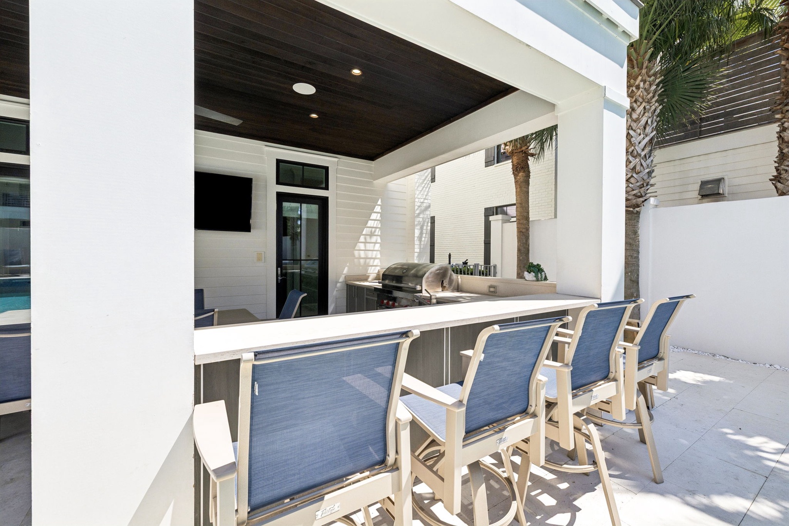 Gather around your private outdoor kitchen bar where chef-worthy meals meet poolside relaxation under elegant covered pavilion.