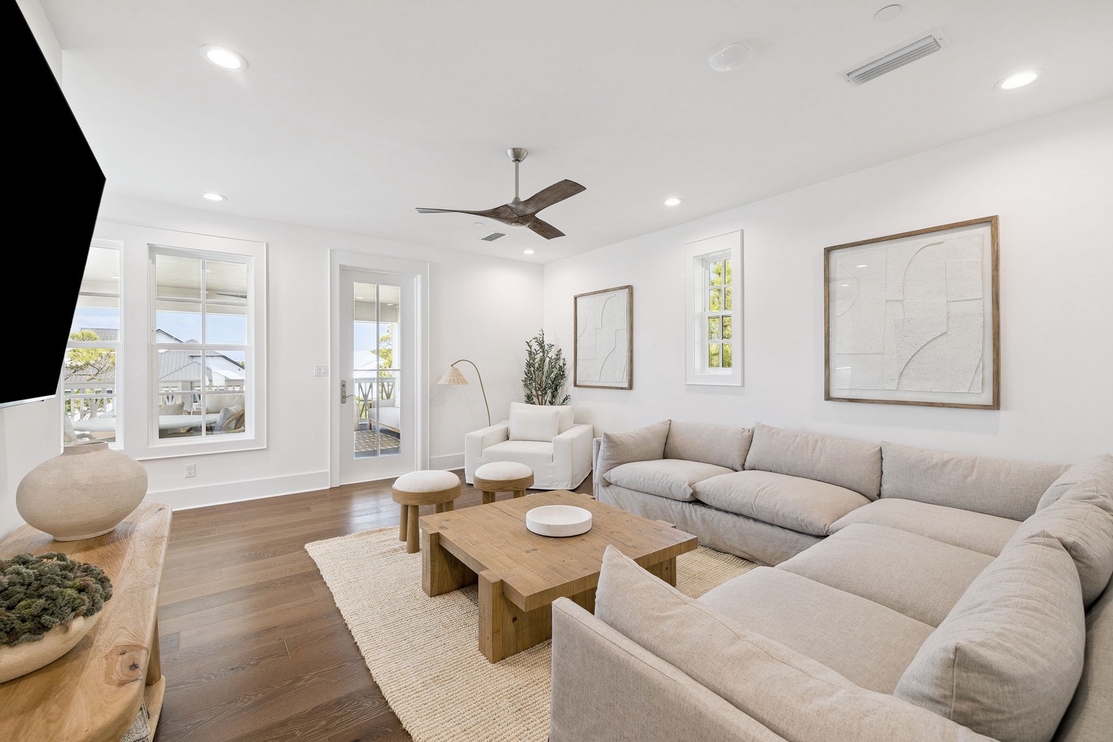Sink into plush seating with your loved ones in this bright, airy living room featuring soaring ceilings and warm wood accents.
