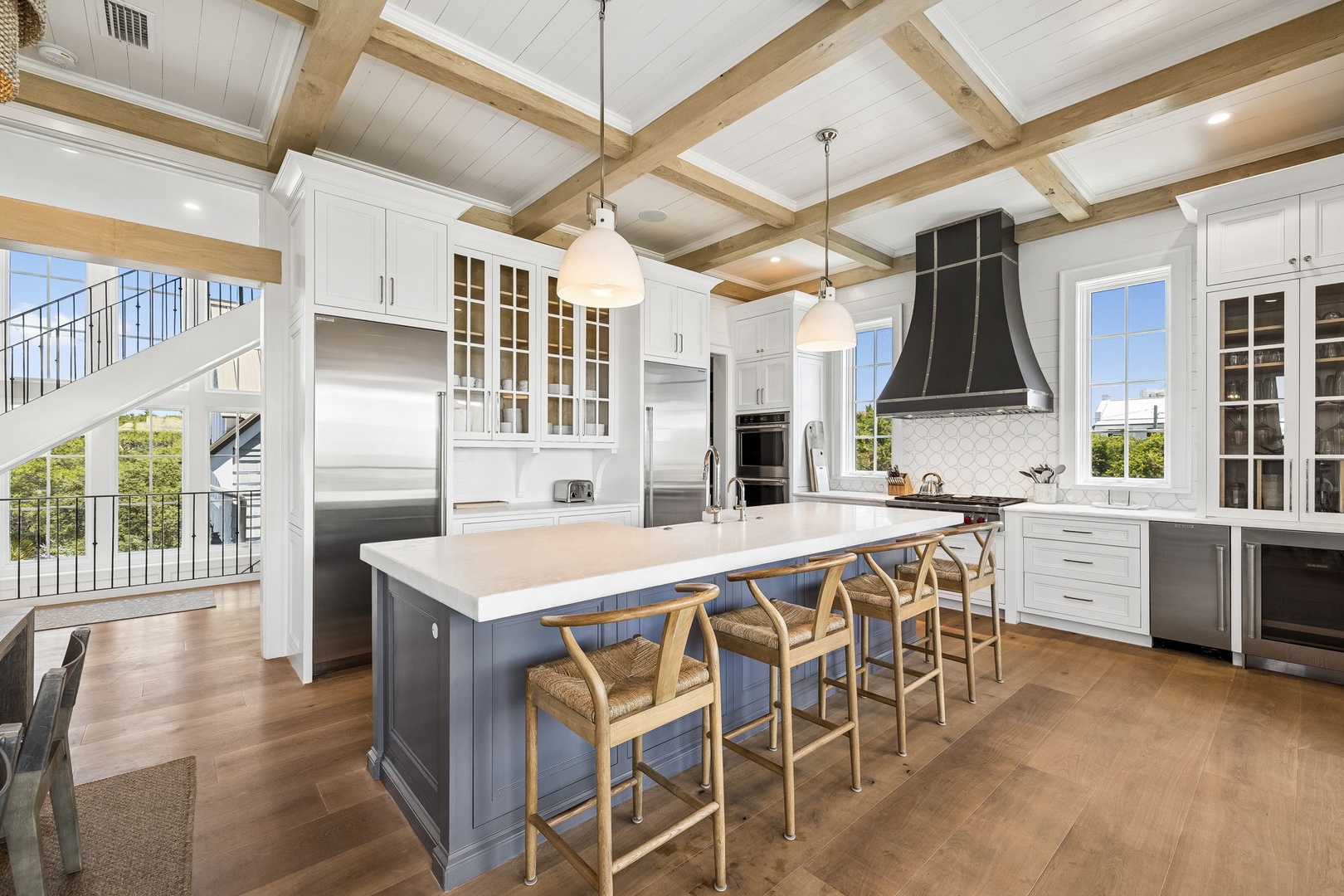 Gather around this stunning kitchen island with ample seating, surrounded by top-tier appliances and natural light streaming through large windows—your perfect space for cooking together.