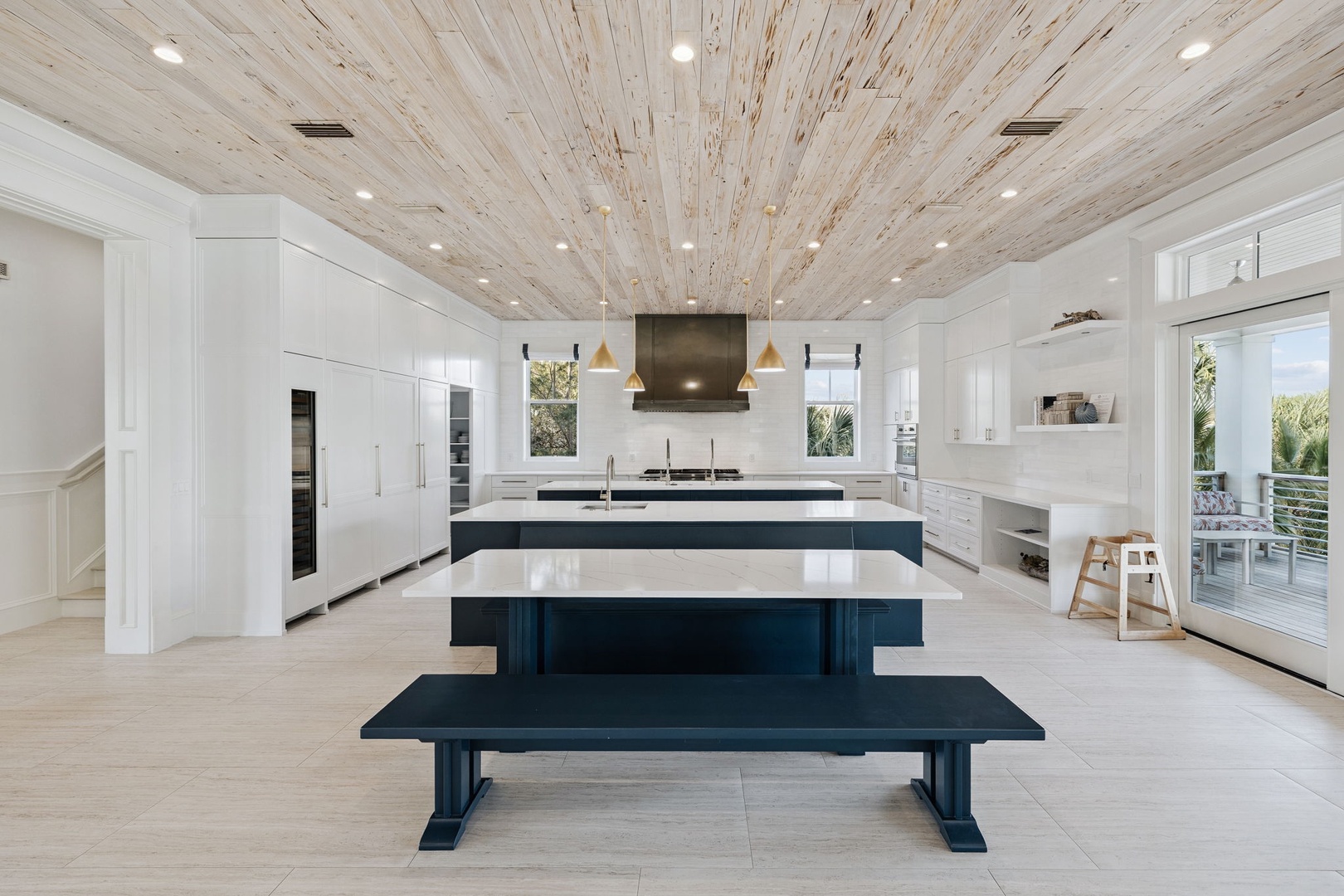 Your chef's dream awaits with sleek white countertops, navy island seating, and stunning reclaimed wood ceiling creating culinary magic.