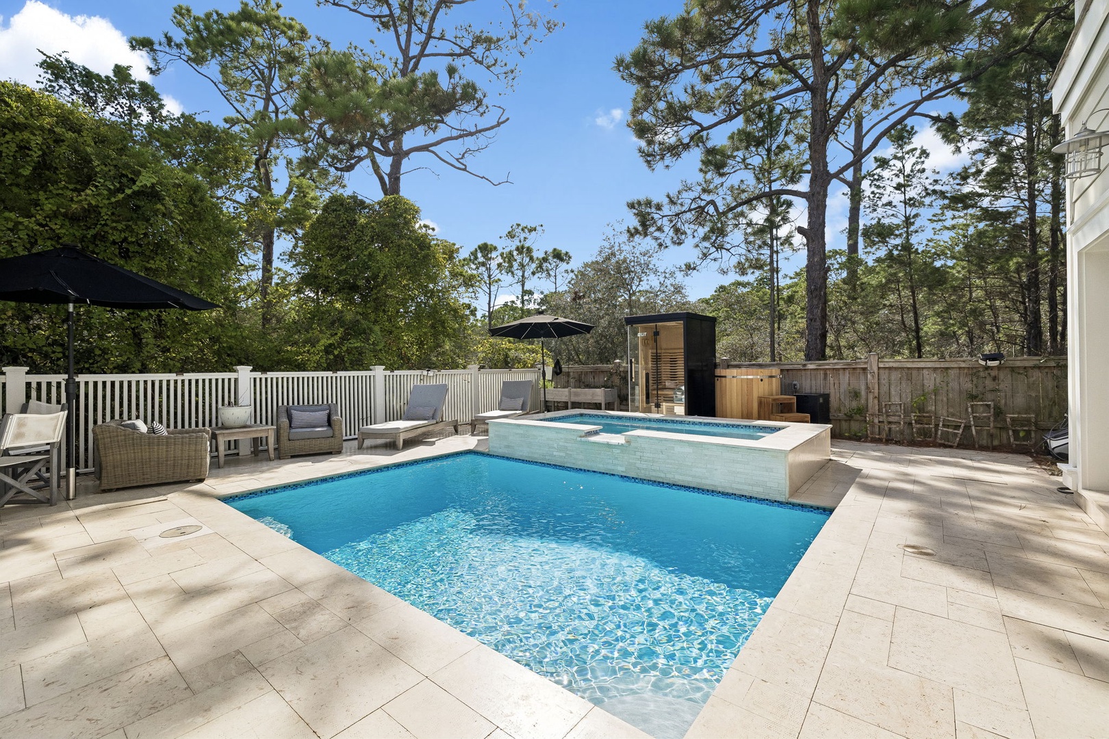 Your private oasis features a sparkling pool, elevated hot tub, and sauna—perfect for unwinding under the shade of towering pines in complete tranquility.