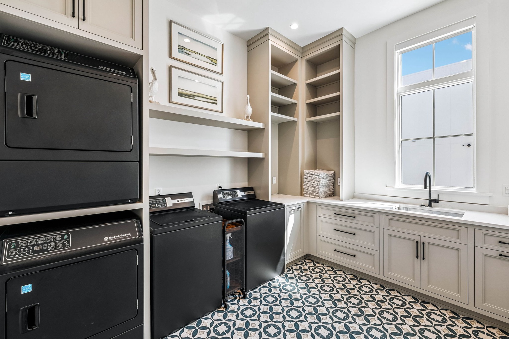 Your laundry room is designed for ease and efficiency, with a washer and dryer, ample shelving, and a functional sink all tucked into a bright, tile-floored space where chores feel a little less like work.