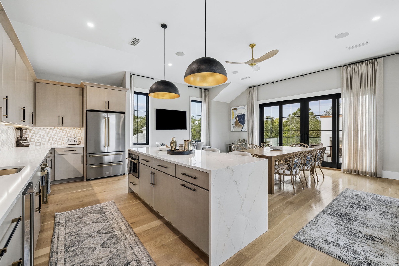 Gather around your stylish marble island where warm pendant lighting and natural light invite conversation. Your modern kitchen flows seamlessly into the dining area, perfect for memorable meals with loved ones.