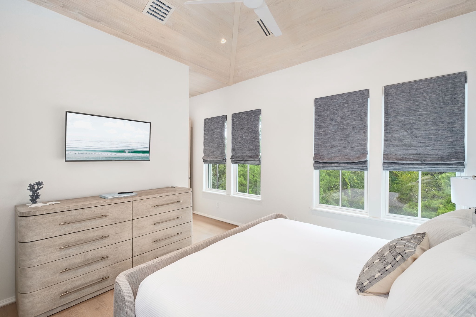 Wake up to lush greenery framed by soft natural light, inviting you to start your day refreshed. Your peaceful retreat features soaring vaulted ceilings and warm coastal tones.