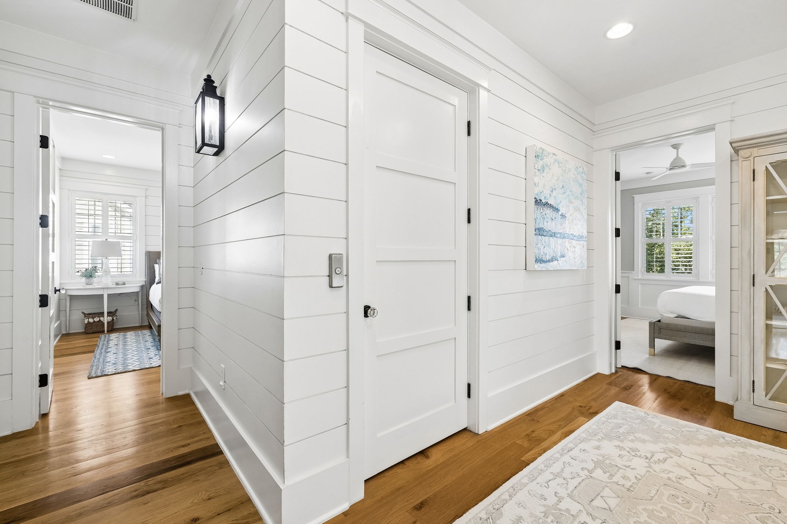 Step into your private coastal retreat, where crisp white shiplap walls and warm hardwood floors create a bright, welcoming atmosphere that connects every room of your home.