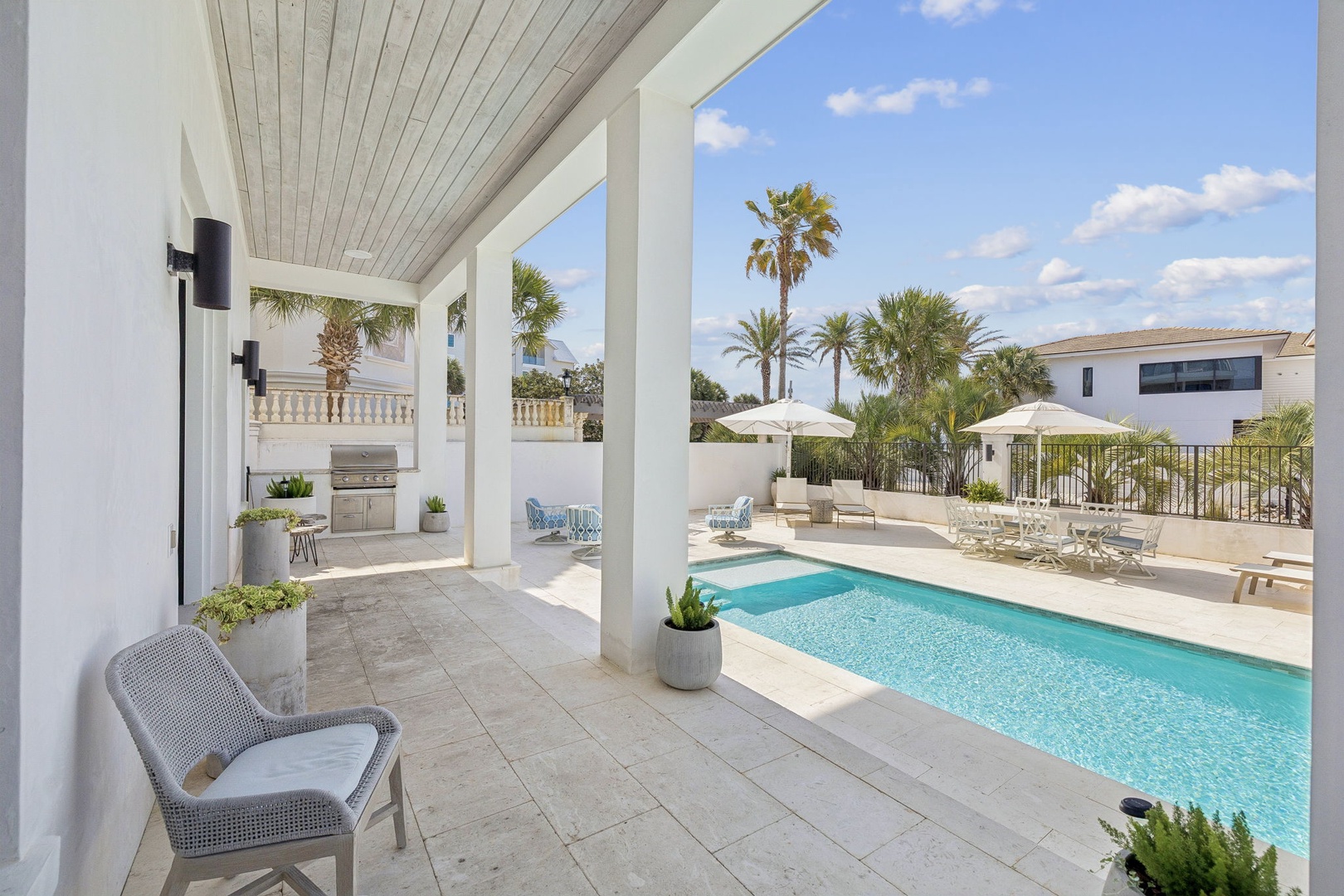 Sink into comfort on your covered terrace overlooking crystal-clear pool waters and swaying palms in this tropical paradise.
