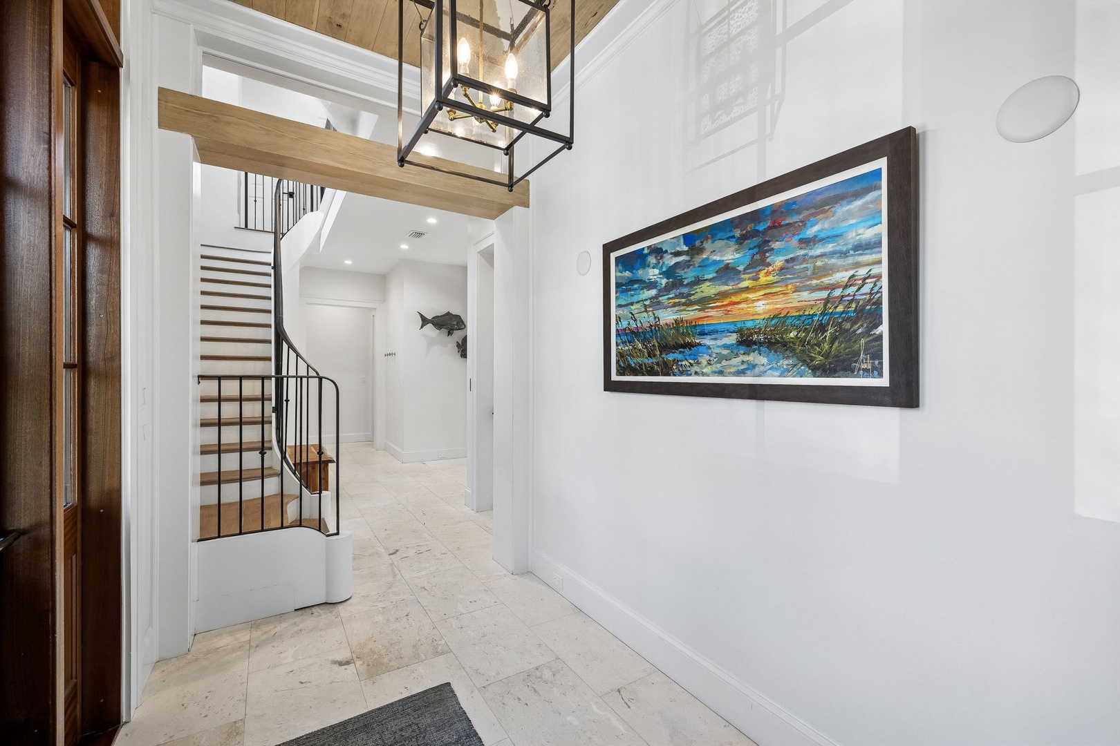Step into a bright, welcoming entryway with soaring ceilings and coastal charm. The spiral staircase invites you to explore your beautiful vacation retreat.