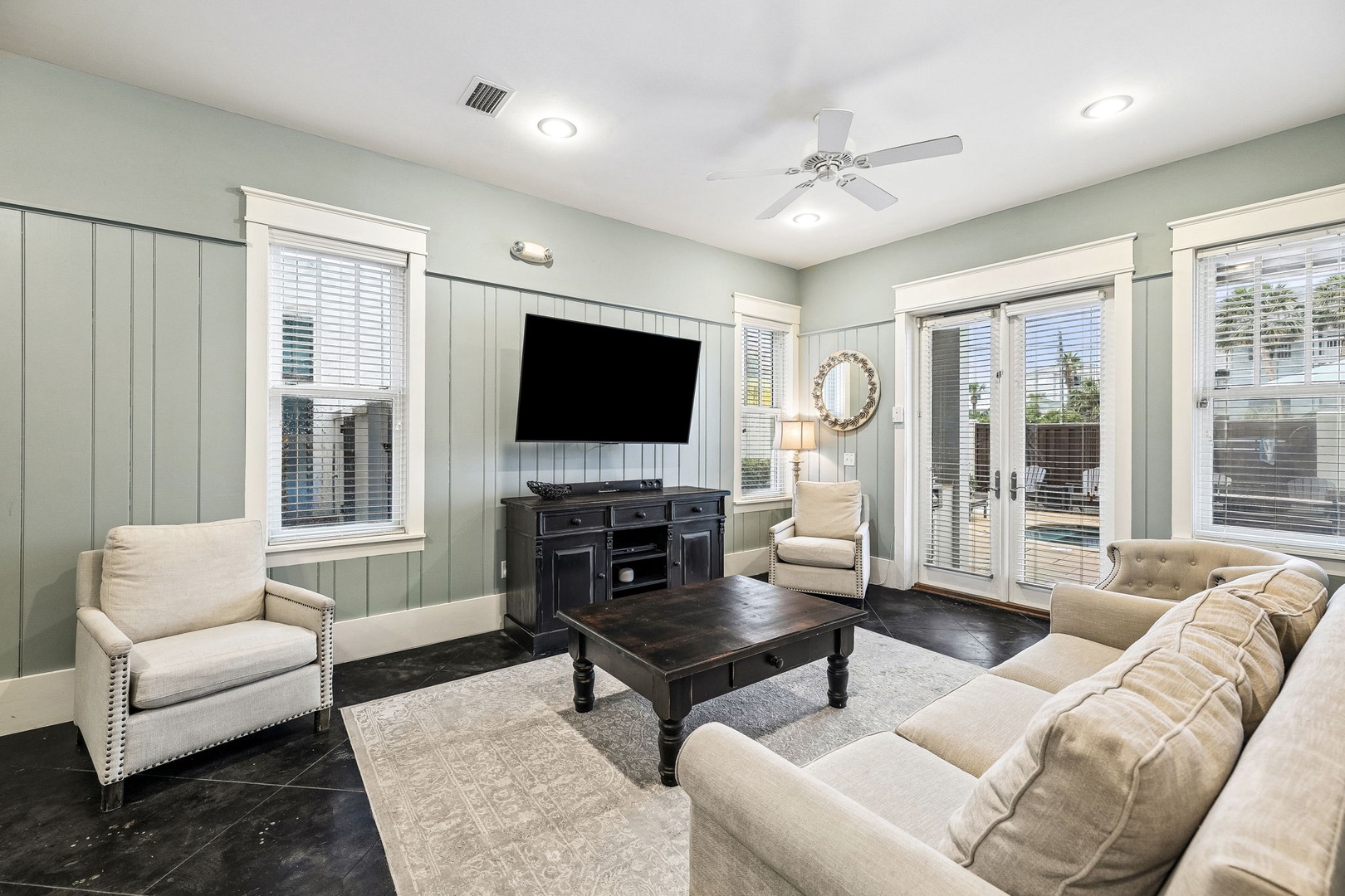 Sink into the plush couch and unwind in your inviting living room, where soft coastal colors meet comfortable seating and French doors open to your private outdoor space.