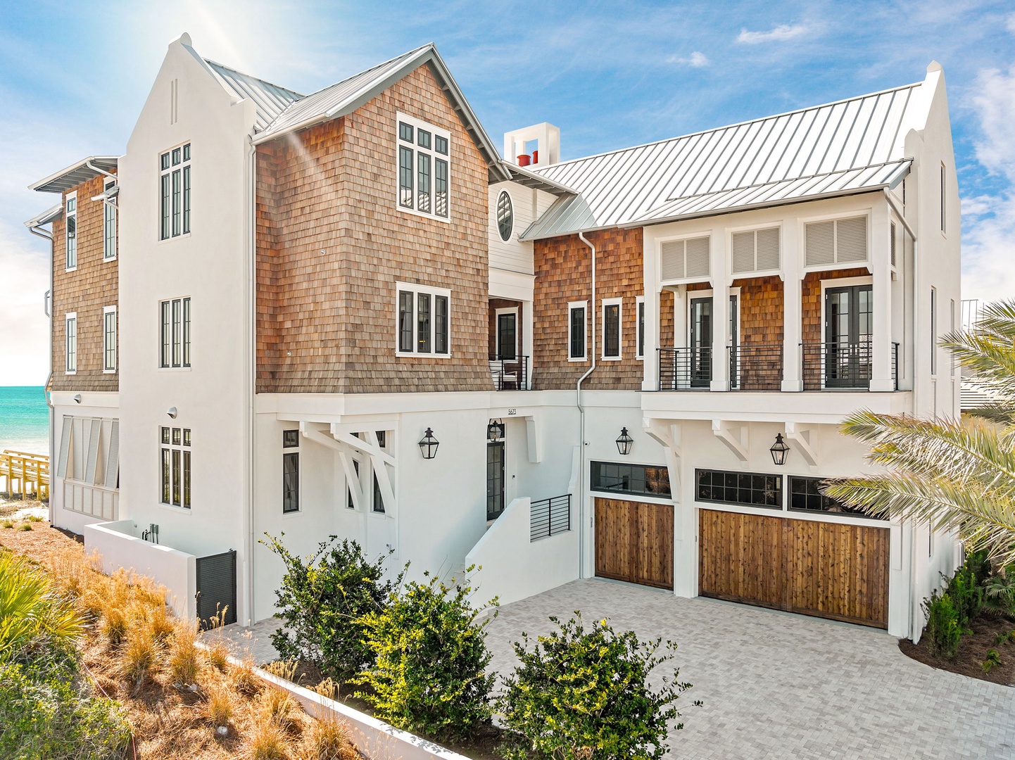 Stunning coastal retreat featuring cedar shake siding, metal roofing, and beachfront location with garage parking.
