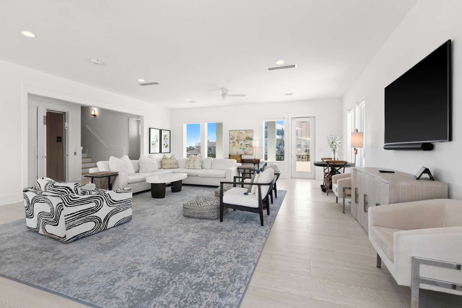 Sink into spacious comfort in this bright living room with plush seating and modern elegance. Your vacation unfolds in style here, surrounded by airy light and inviting furnishings.