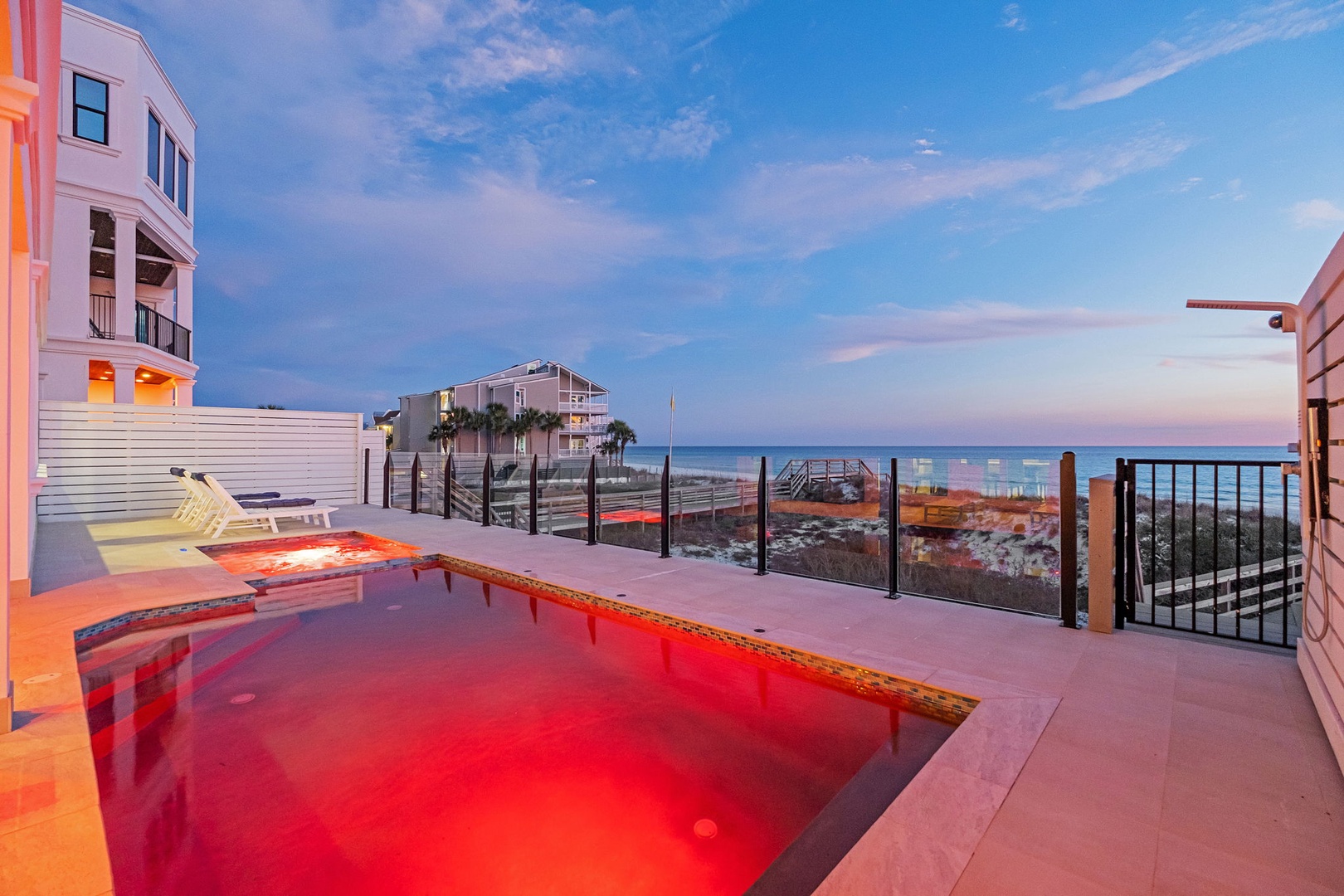 Stunning beachfront property featuring a private pool deck with ocean views and modern coastal architecture.