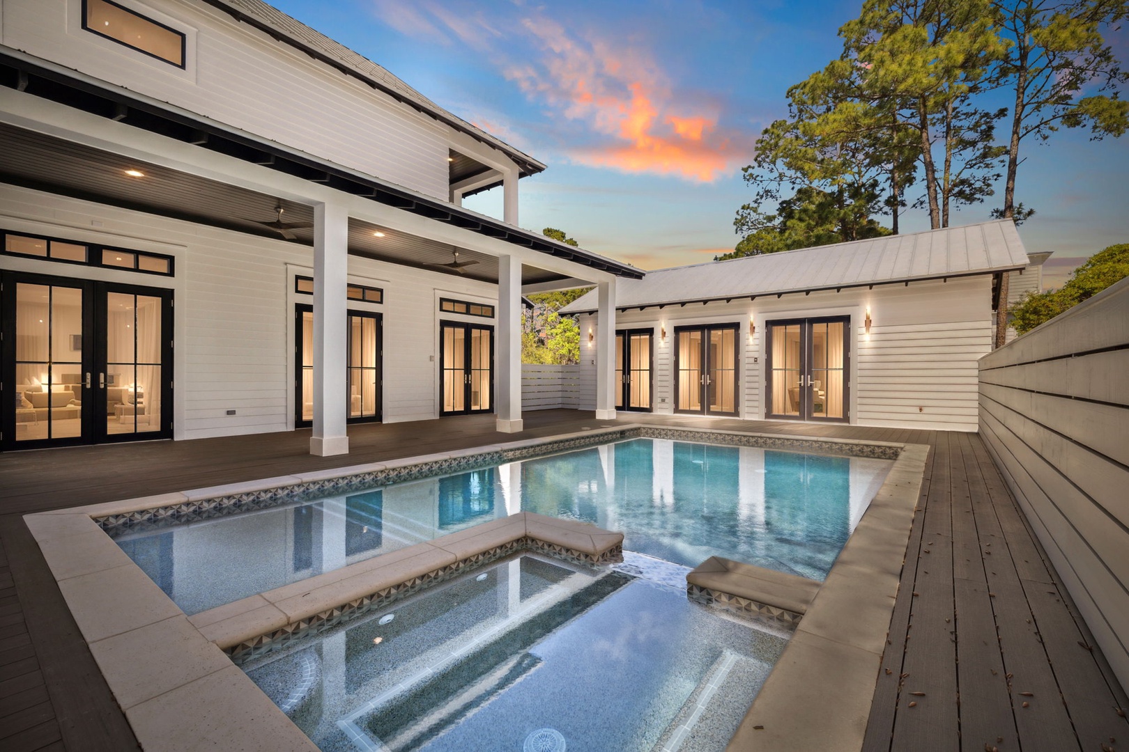 Modern luxury home with private pool and spa surrounded by natural beauty at sunset.
