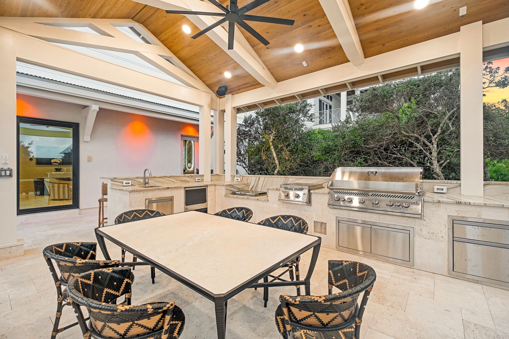 Imagine your mornings here—coffee at the outdoor dining table, stunning vaulted wood ceilings overhead, and a fully-equipped kitchen ready for your alfresco feasts as the sun sets.
