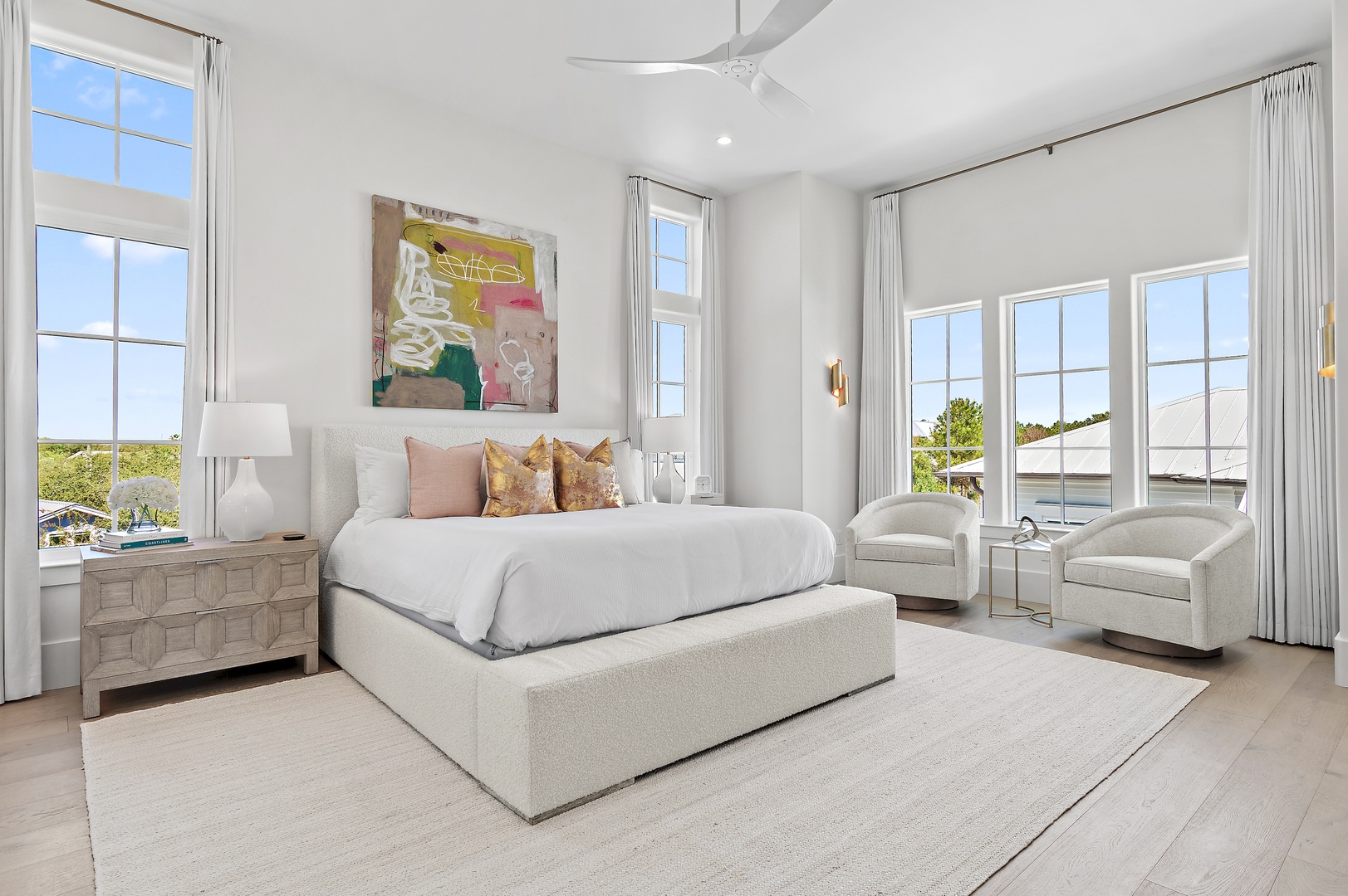 Your serene bedroom sanctuary awaits with a plush king bed, elegant furnishings, and bright natural light streaming through expansive windows, inviting you to unwind in style.