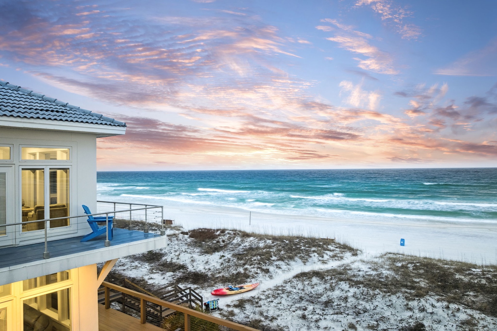 Beachfront property offers stunning ocean views with direct beach access and dramatic sunset skies over pristine white sand.